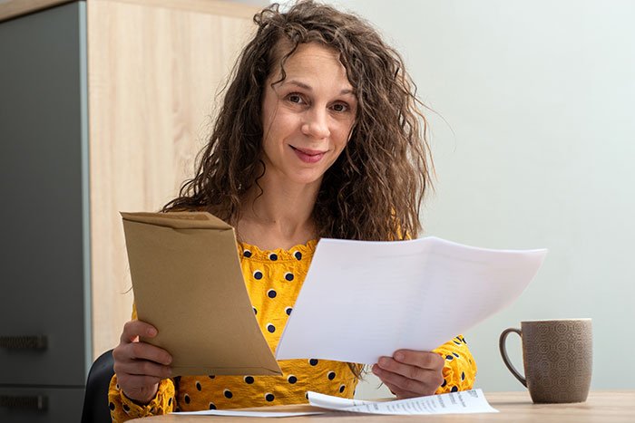 woman in yellow top with paper work for funding application