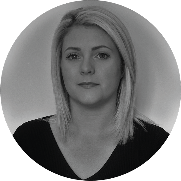 Black and white portrait of a woman with shoulder-length blonde hair, wearing a black top, looking at the camera