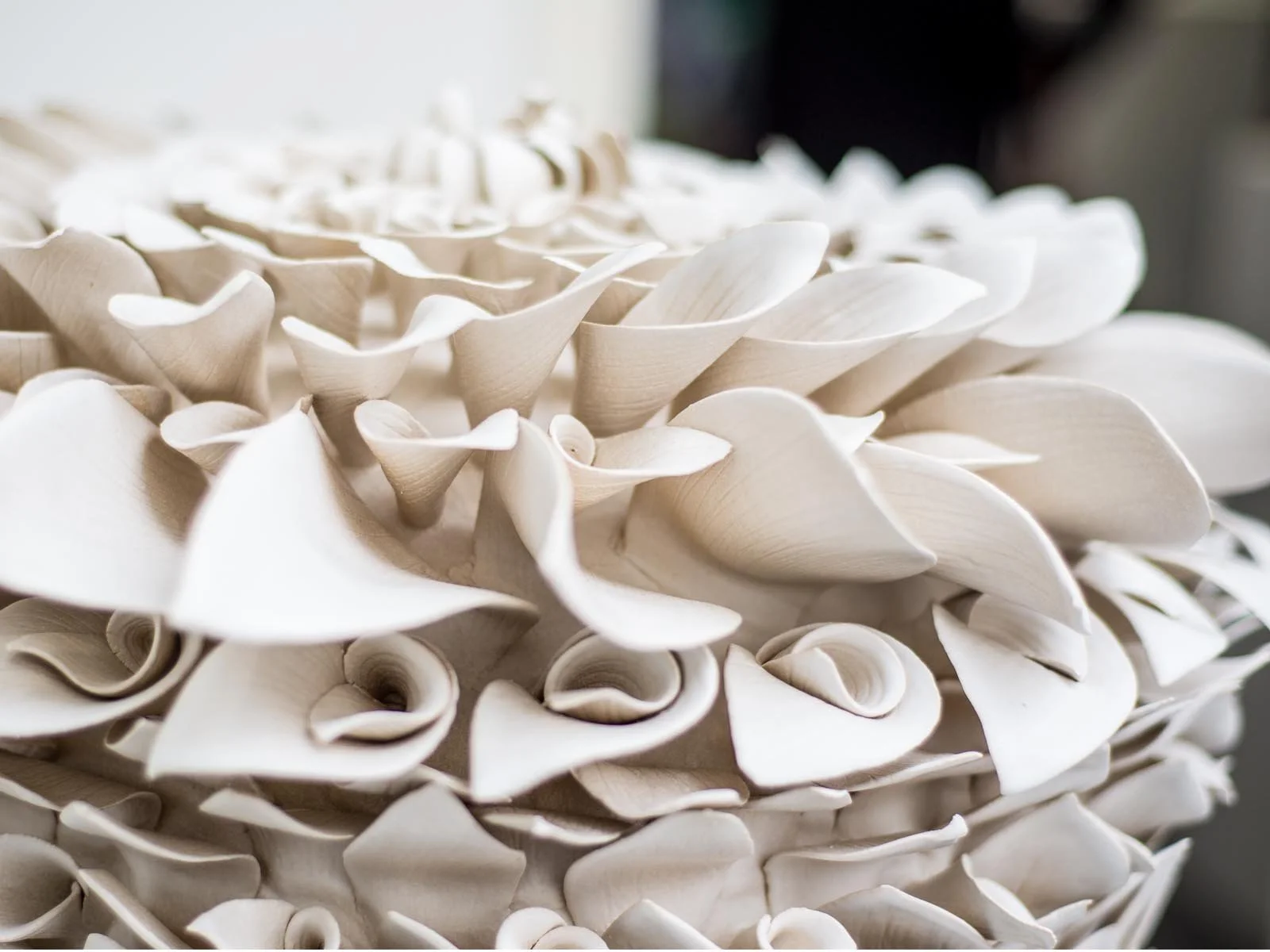 Close-up of a textured cream-colored decorative object made of curled and layered paper or similar material.