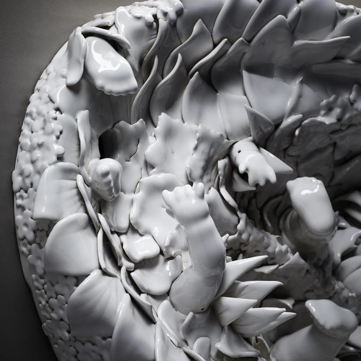 Close-up of an abstract, textured white ceramic sculpture with sharp, organic shapes.