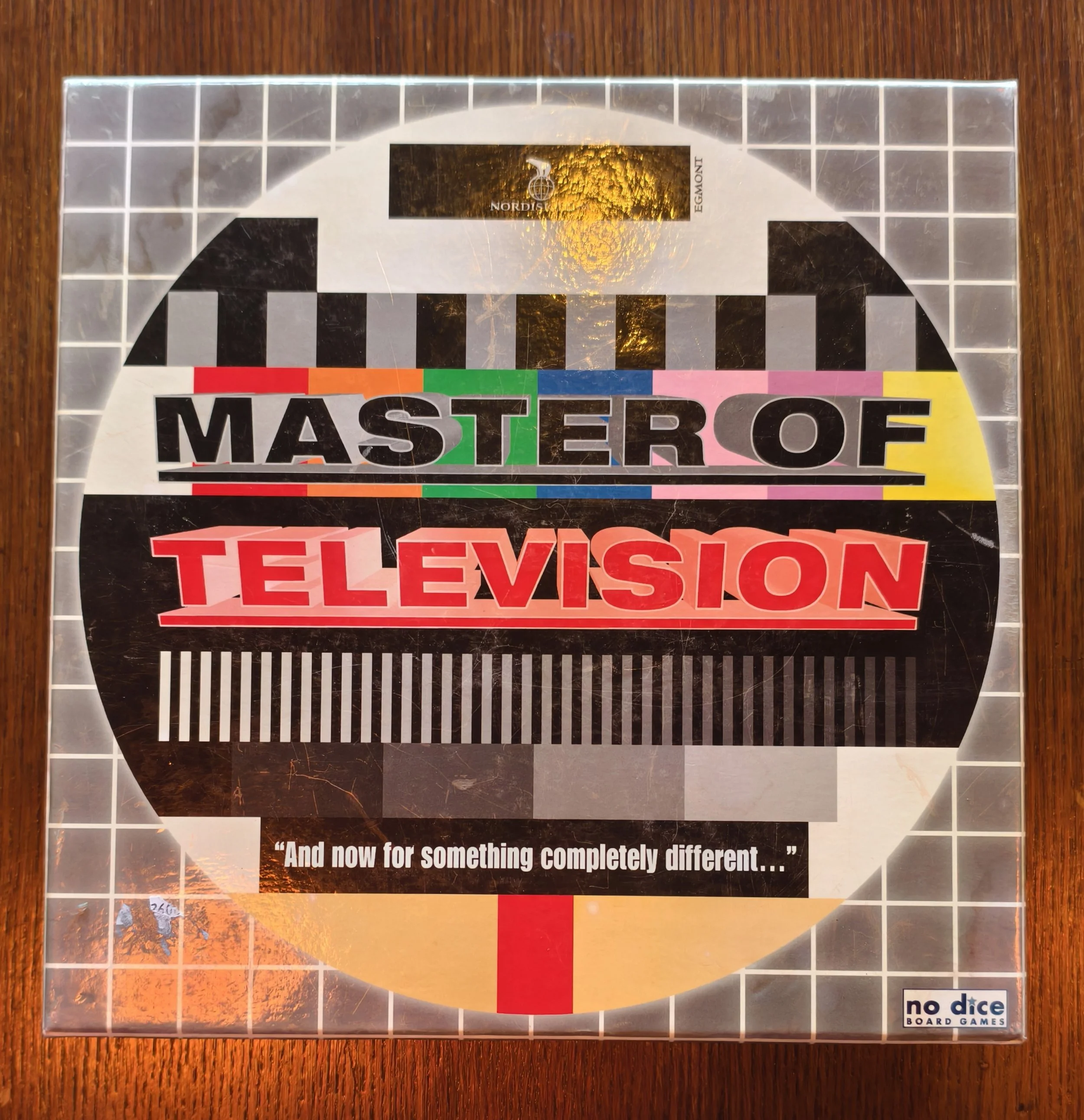 Close-up of a board game titled 'Master of Television', with colourful lettering, a black background, and the subtitle quote, 'And now for something completely different...'. 