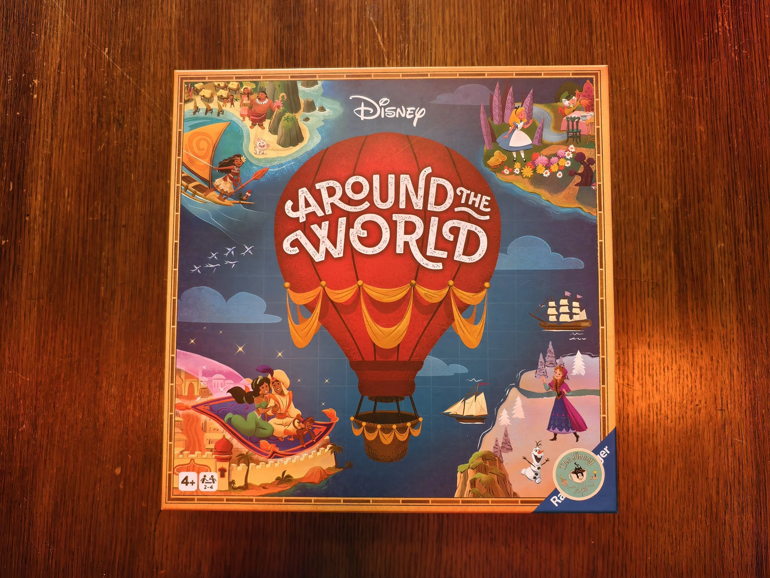 Colorful illustrated board game titled 'Around the World' with various scenes depicting travel and adventure, featuring hot air balloons, ships, and characters from different cultures.