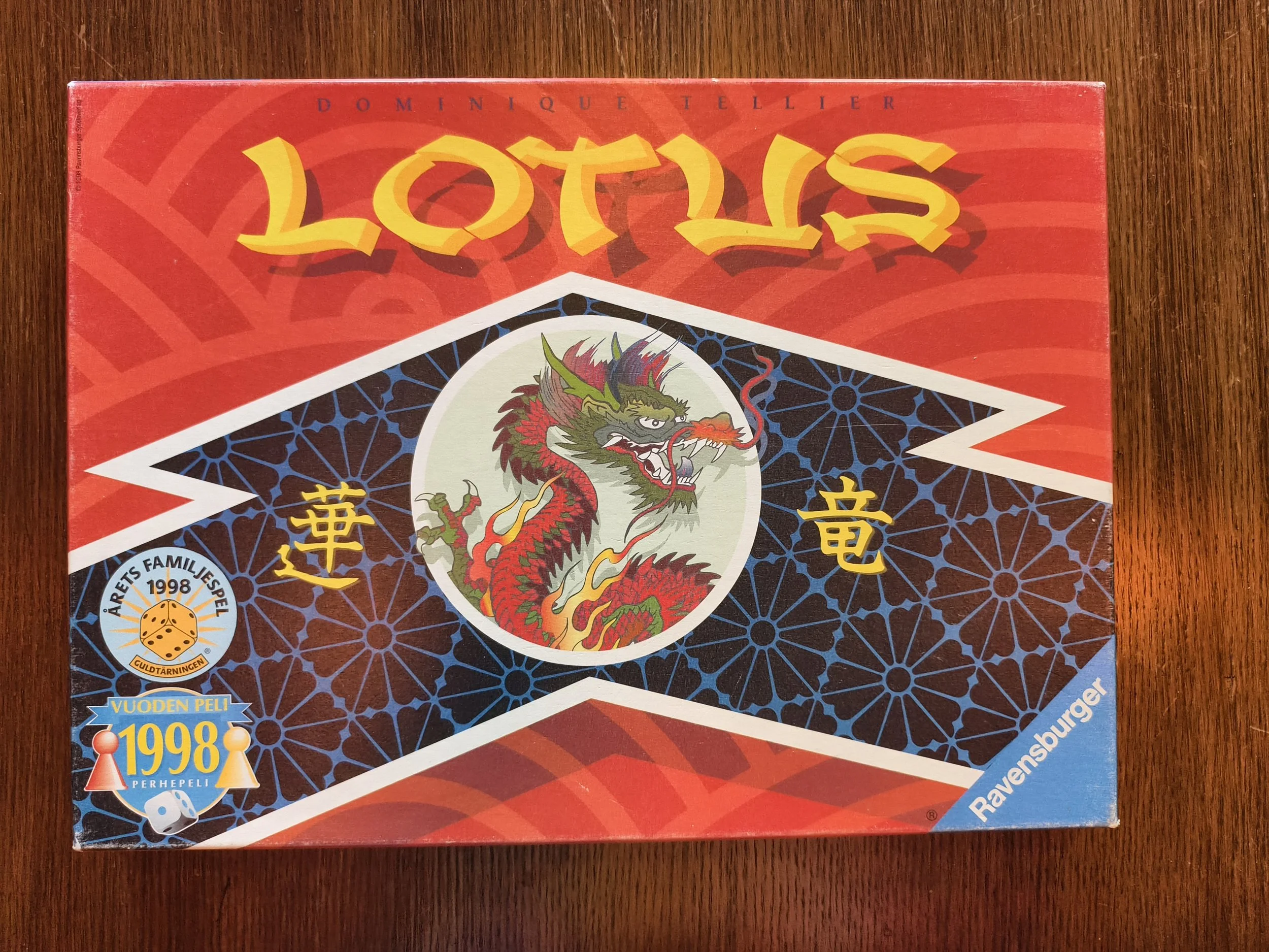 Board game box for 'Lottis' with a colorful dragon illustration and various labels indicating the game's details and origin.
