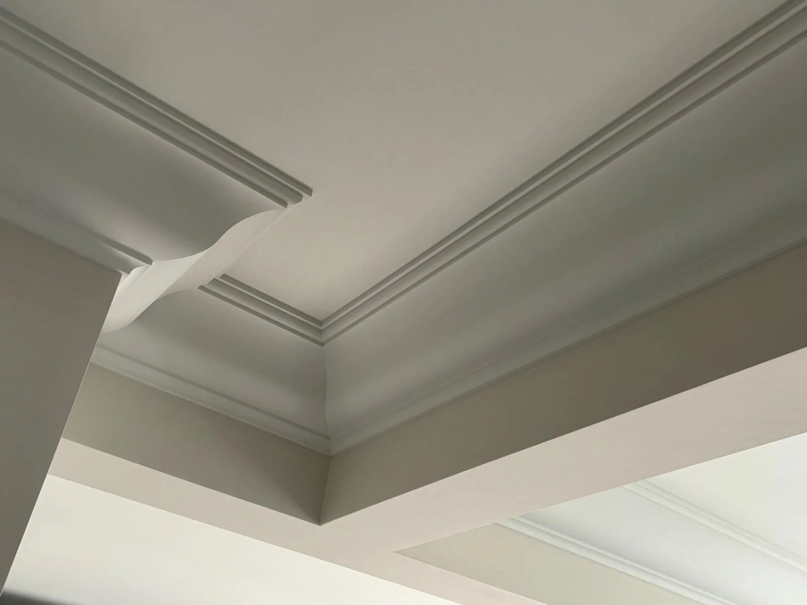 Ceiling with decorative crown molding and an air vent.