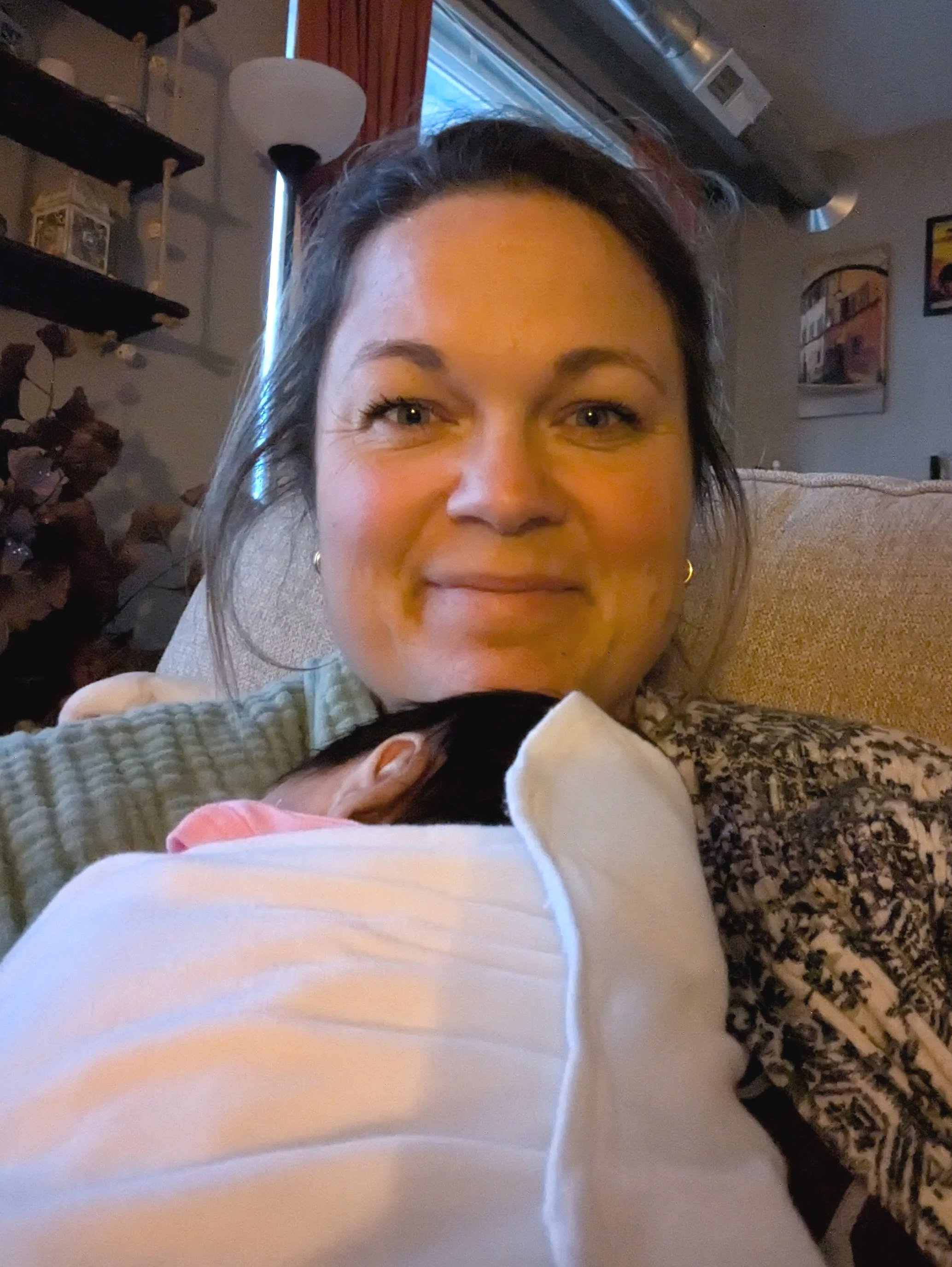 Central Iowa Doula smiling while holding a newborn.