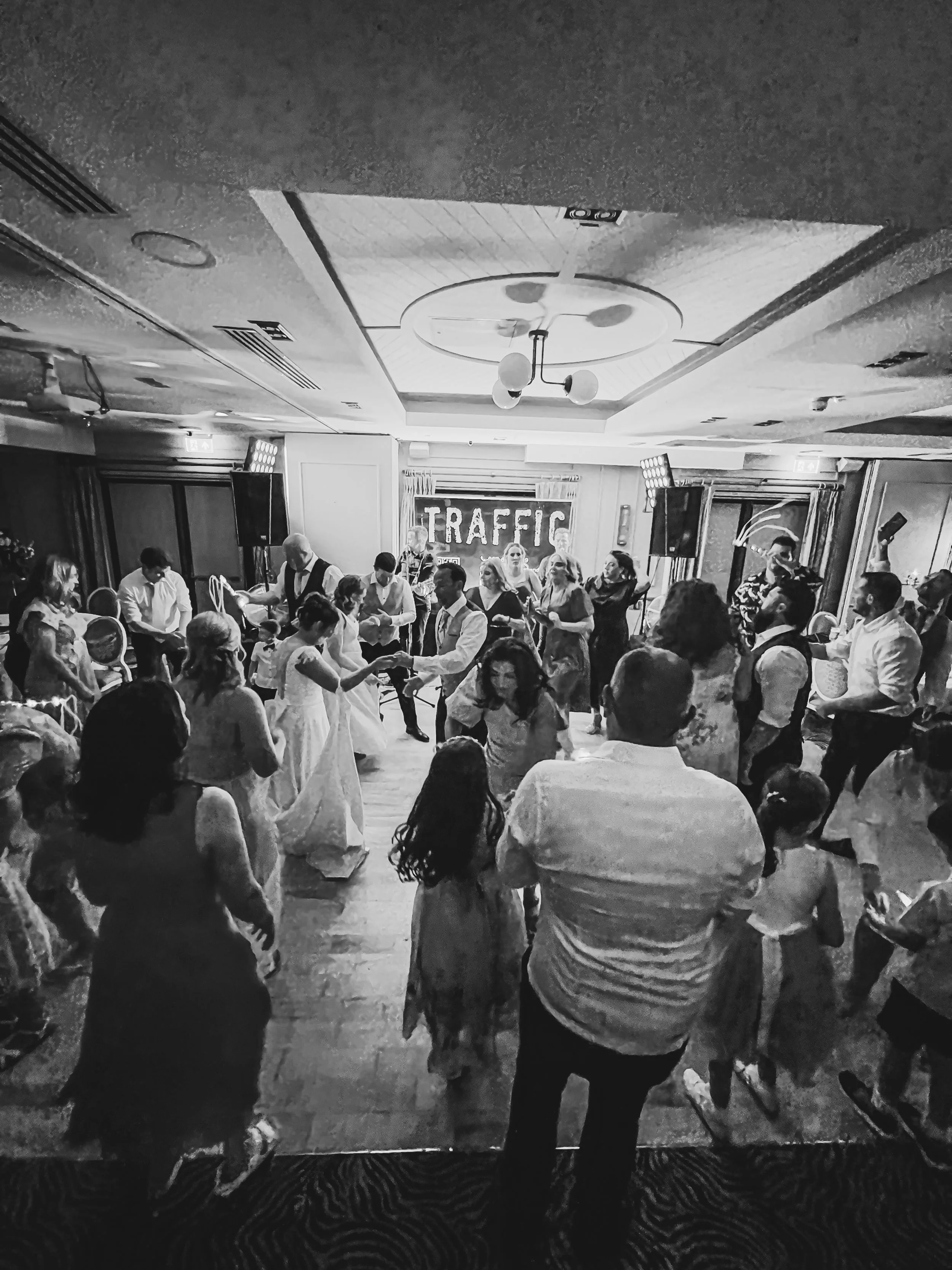People dancing at a wedding reception with Traffic Wedding Band playing in the background