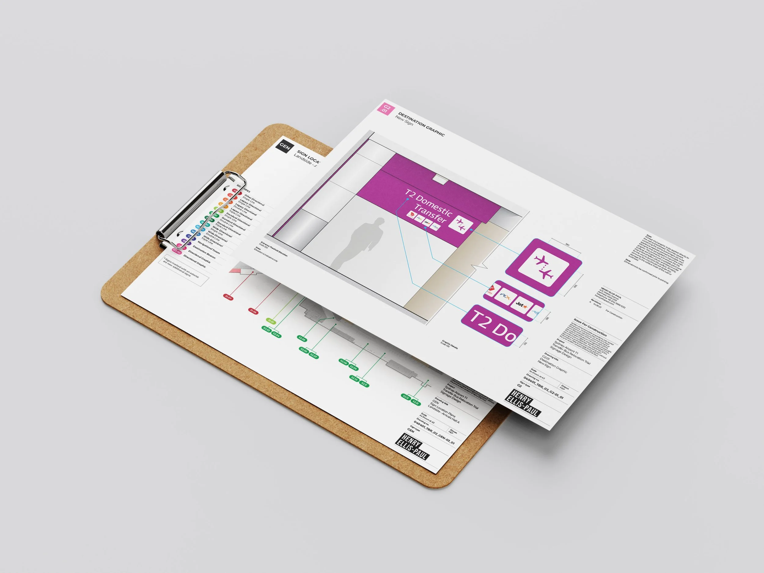 Architectural floor plan and graphic design mockup on a clipboard with drawing tools, placed on a light grey surface.