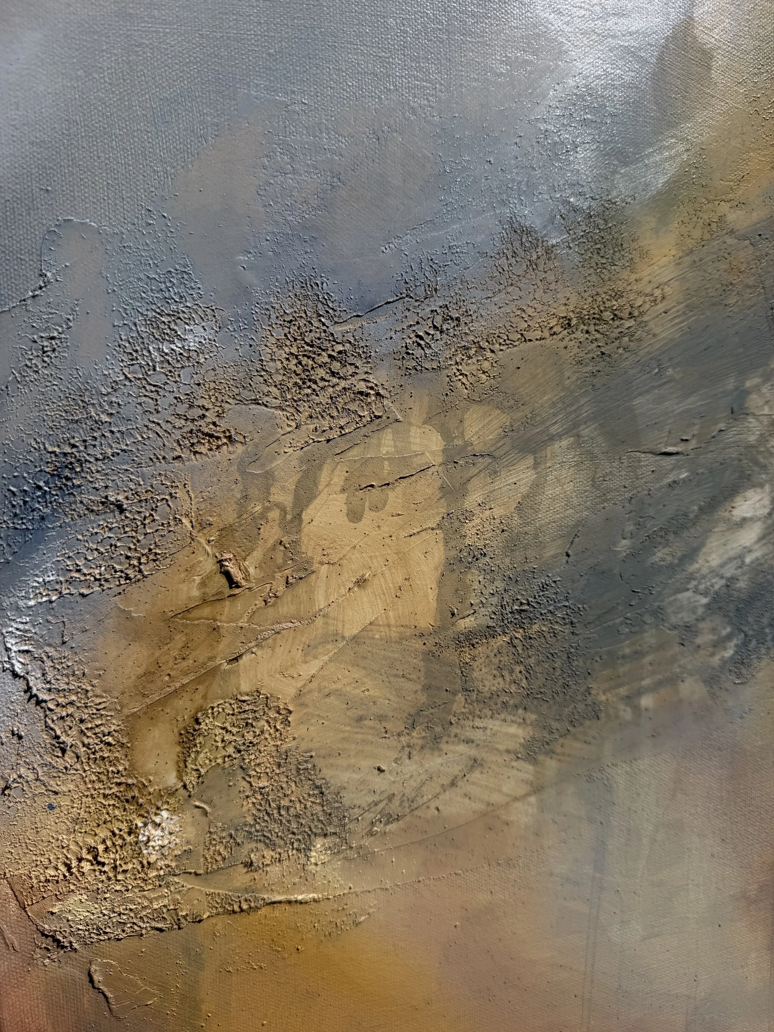 Close-up of a textured, painted surface with cracks, rough patches, and layered colors of blue, beige, and gray.