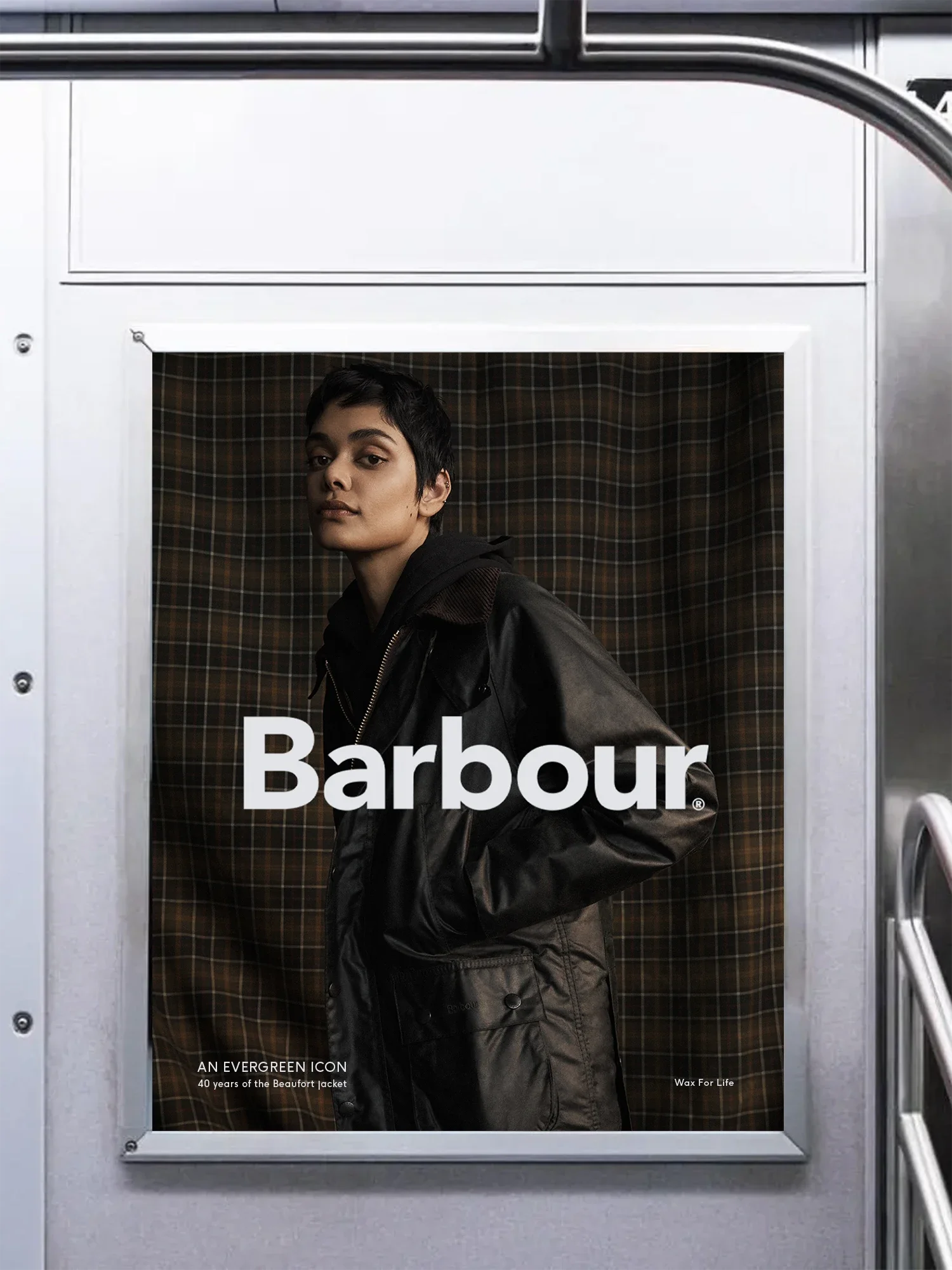 Magazine cover featuring a young person with short dark hair wearing a black jacket, standing in front of a plaid background, with 'Barbour' written across the image. Additional text mentions 'AN EVERGREEN ICON' and '40 years of the Beaufort jacket'.