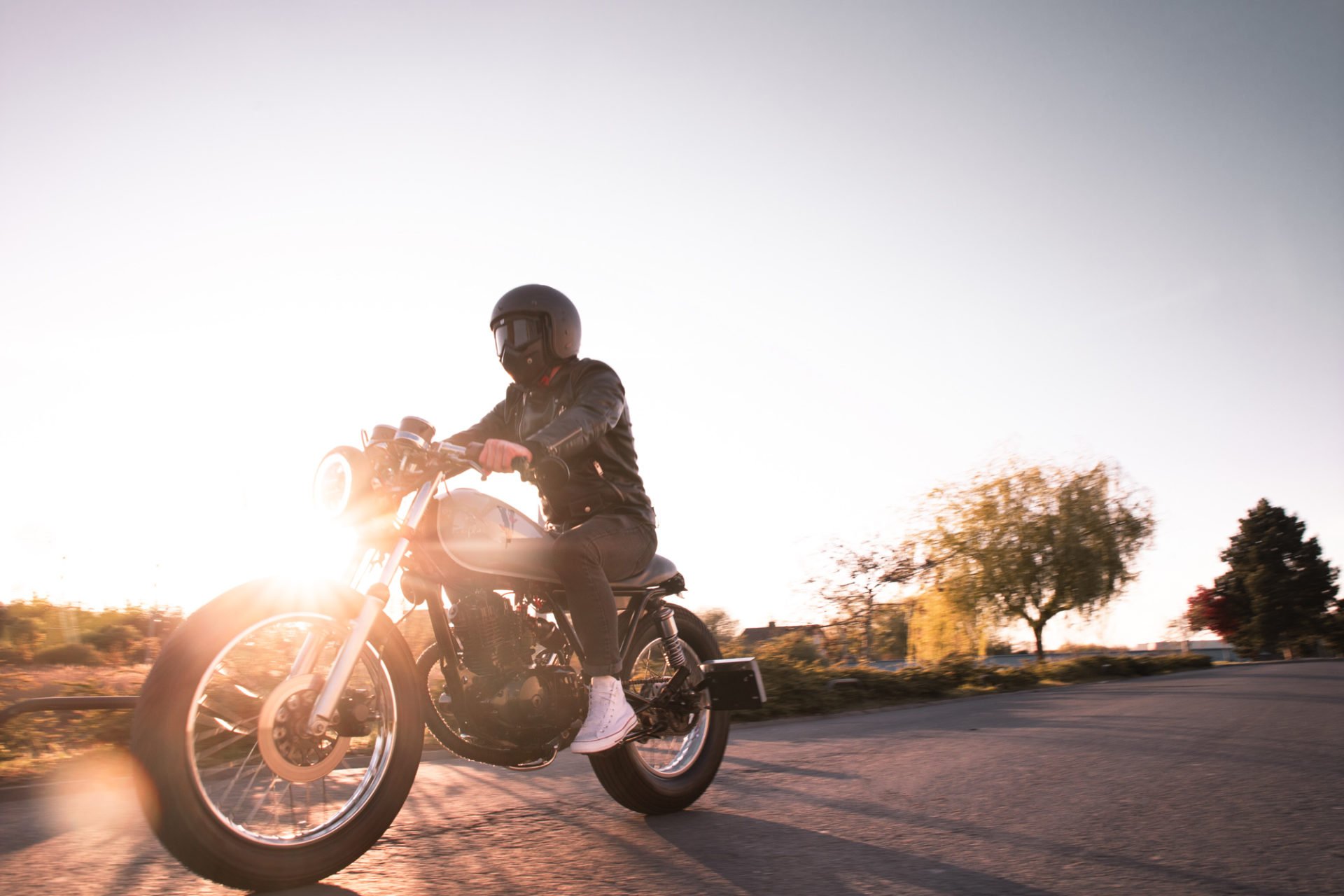 Personne portant un casque de moto, roulant à vélo électrique lors du coucher du soleil dans un environnement naturel