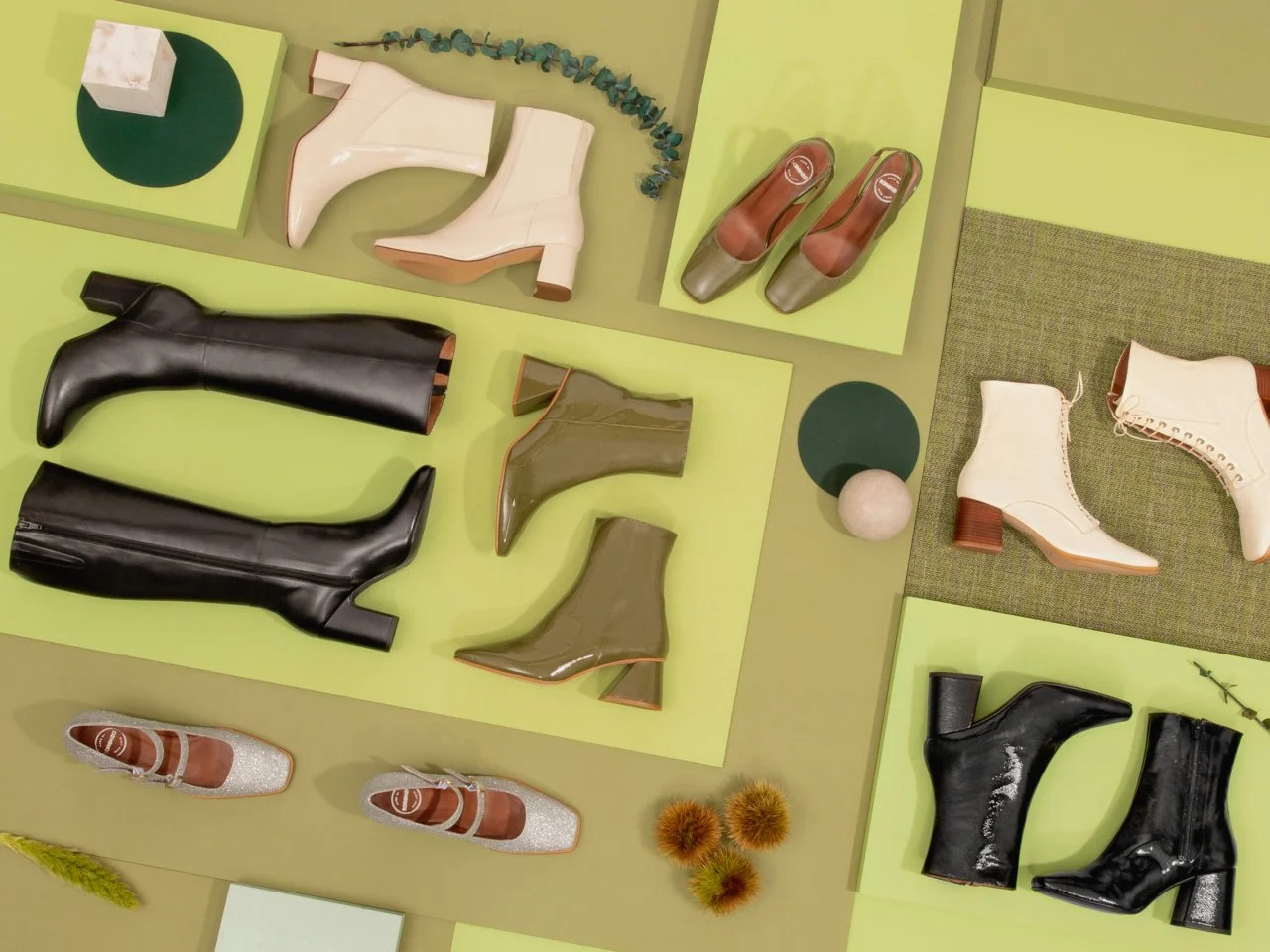 Différents modèles de chaussures à talons, bottes et baskets, disposés sur des surfaces vertes et mineures. Sarenza