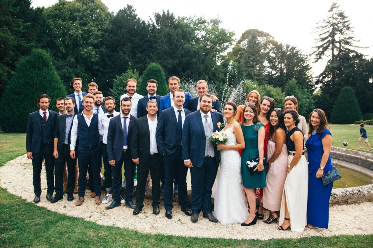 Groupe de personnes en costume et robes de soirée lors d'un mariage dans un jardin