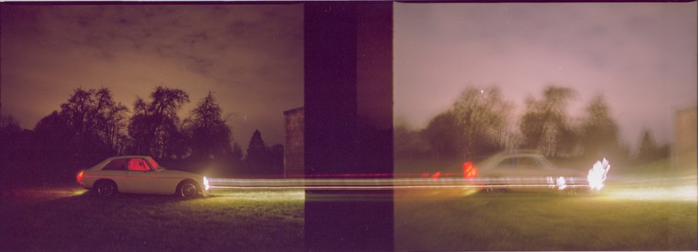 Deux voitures en mouvement la nuit, avec des effets de lumière dû à la longue exposition, séparées par une division verticale