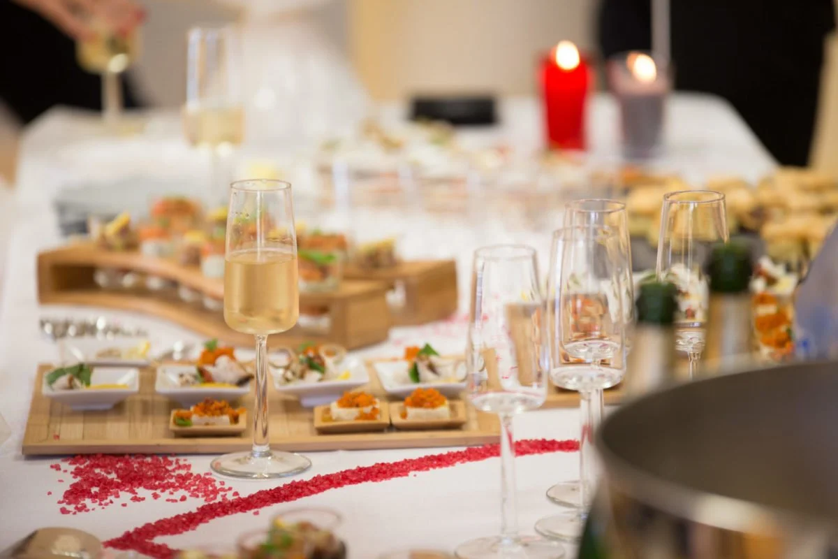 Verres de champagne et amuse-bouches sur une table de fête élégante.