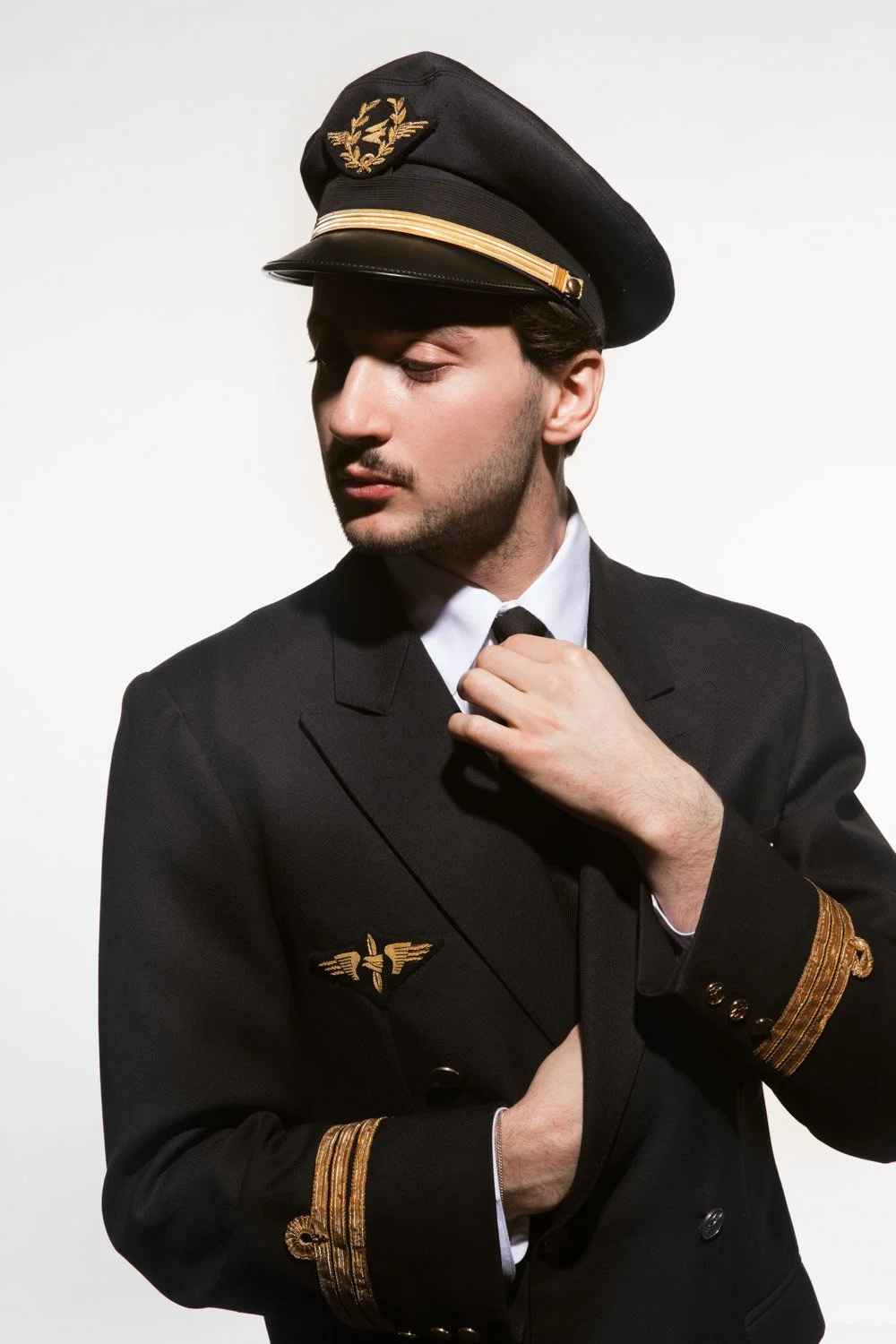 Lord esperanza porte un uniforme de pilote avec un chapeau de pilote orné de broderies dorées.