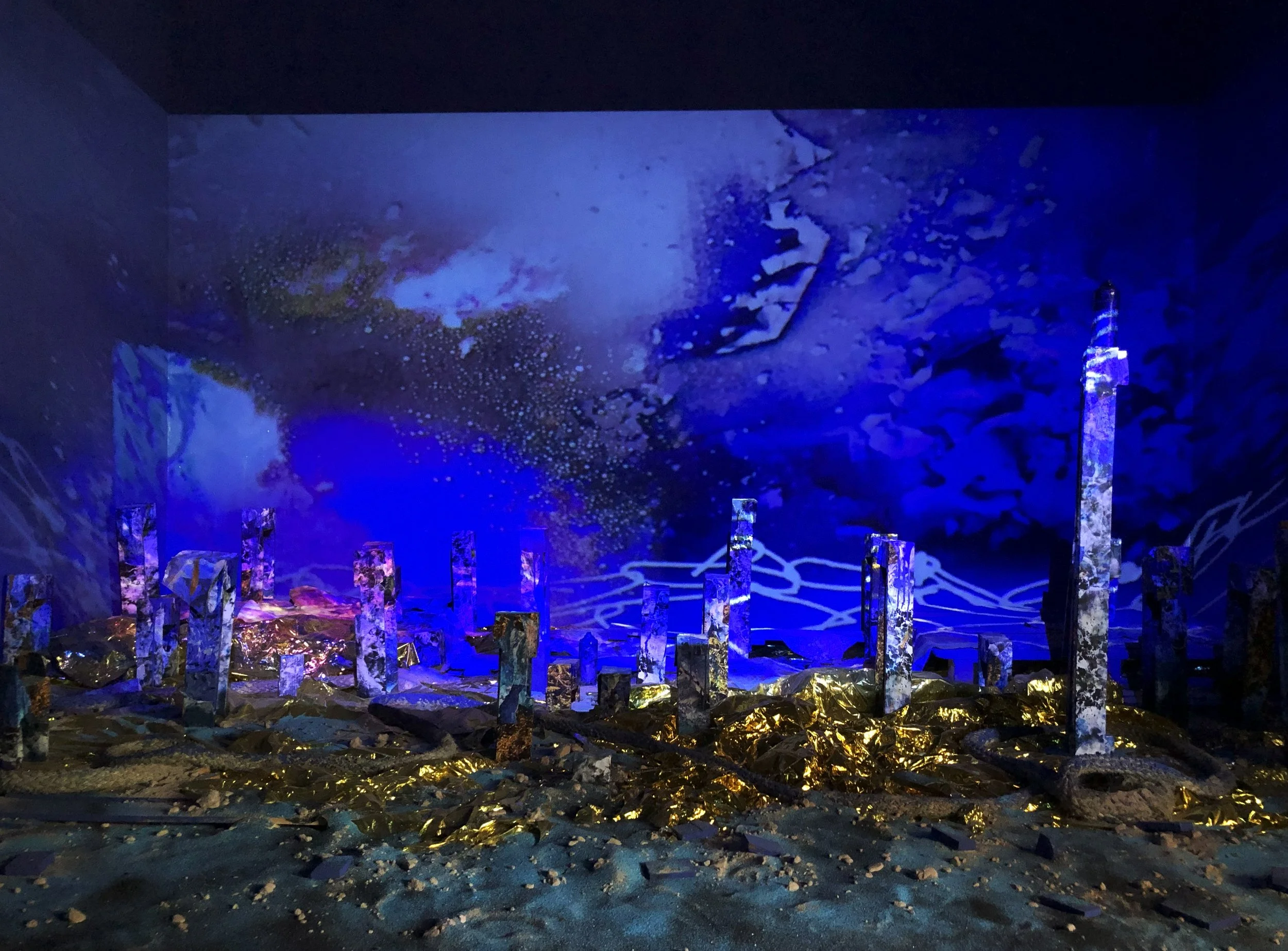 Installation réalisée à la biennale de Dakar en 2024 où l'artiste Louisa Marajo imagine un fond marin du futur, composé de totems de bois, de couvertures de survie.... C'est l'image d'une forêt sous-marine en hommage à tous les disparus en mer.