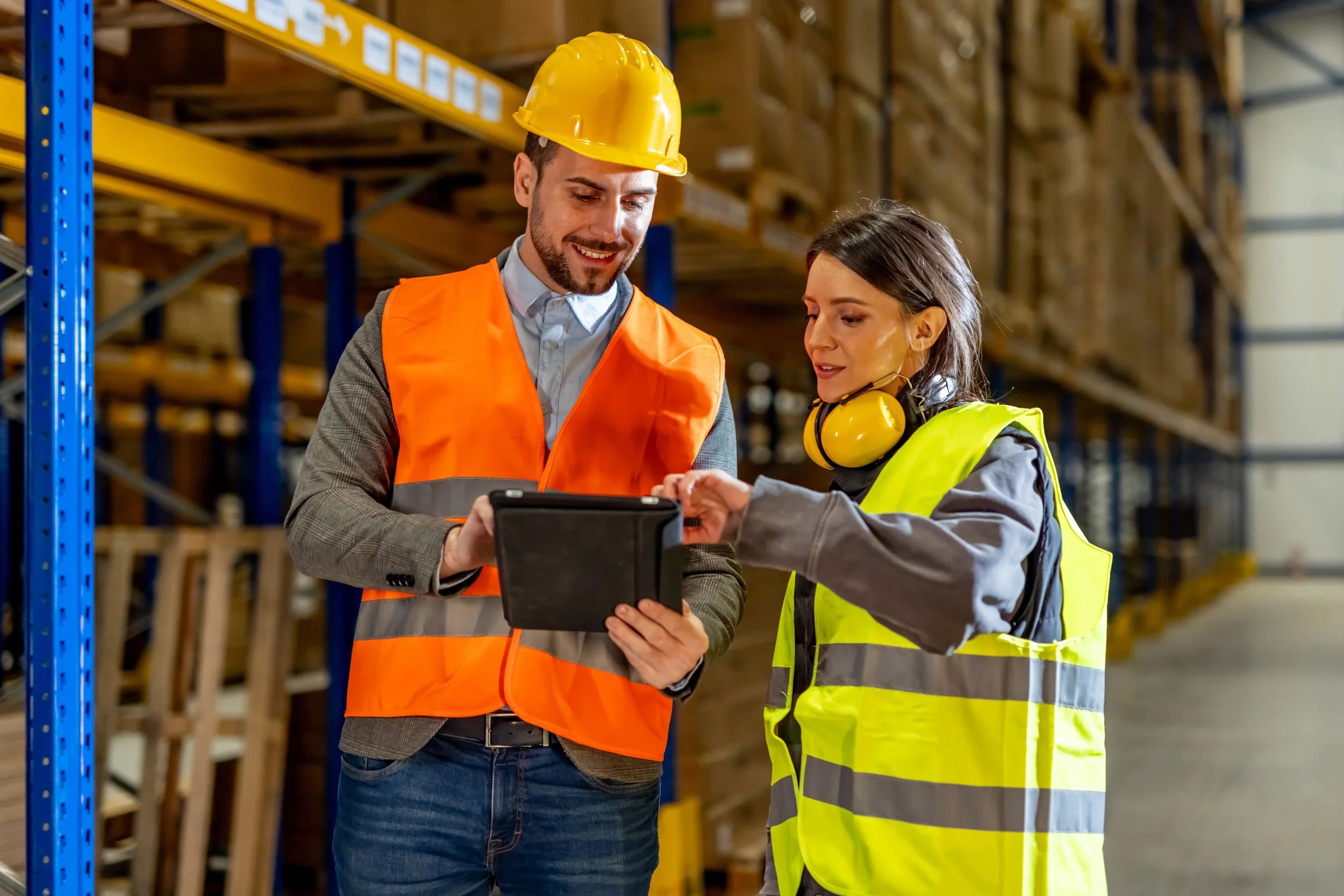 Warehouse professionals using a tablet to improve manufacturing workflows, operations, and team efficiency.