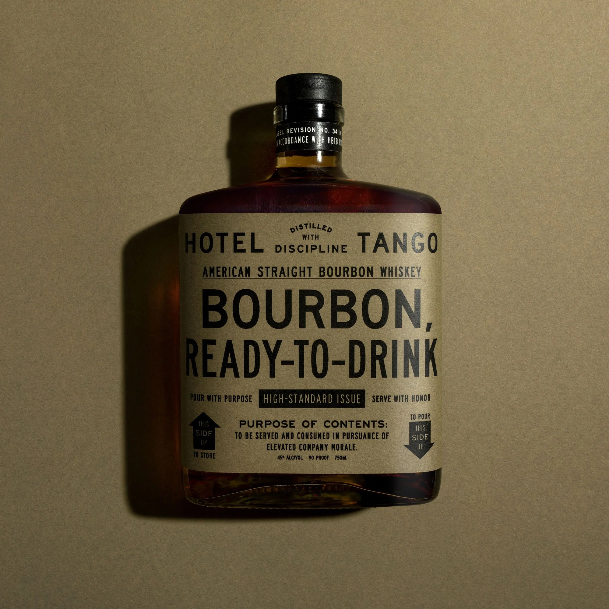 Bottle of Hotel Tango straight bourbon whiskey with a beige label against a neutral background.