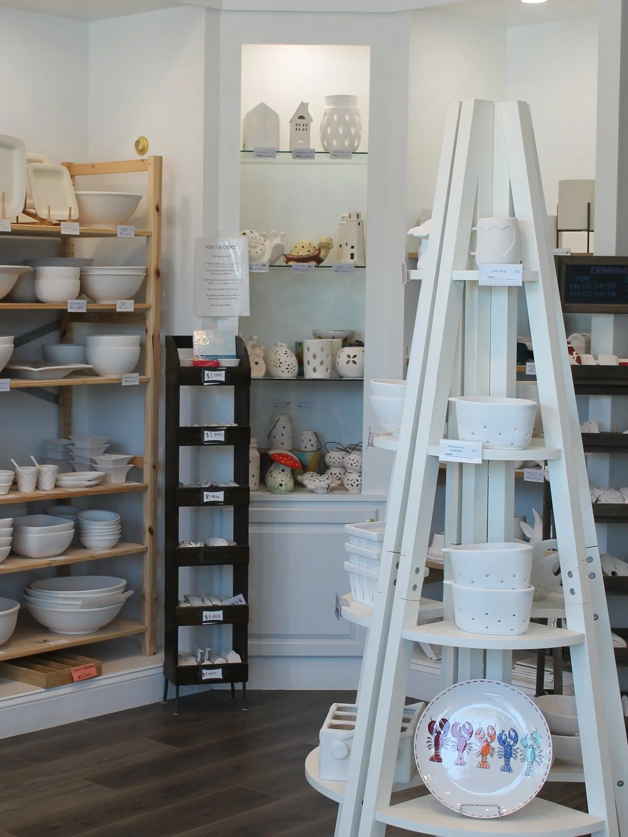 Display of white ceramic home decor items, including bowls and plates, in a gift shop.