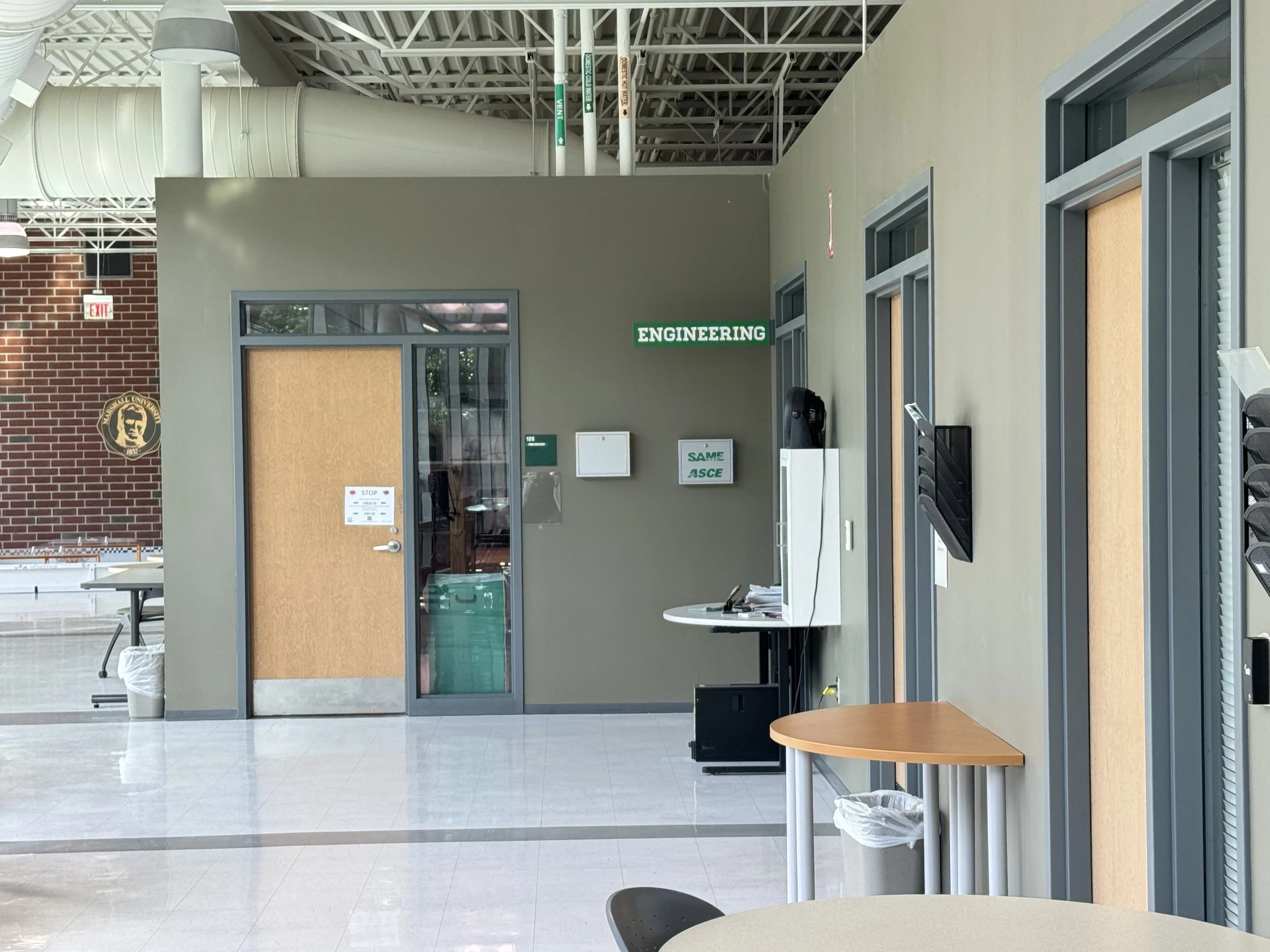 Interior engineering space with exposed mechanical piping and ductwork at Marshall University.
