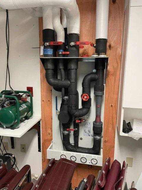Commercial plumbing and mechanical piping installation with valves, equipment and utility connections.