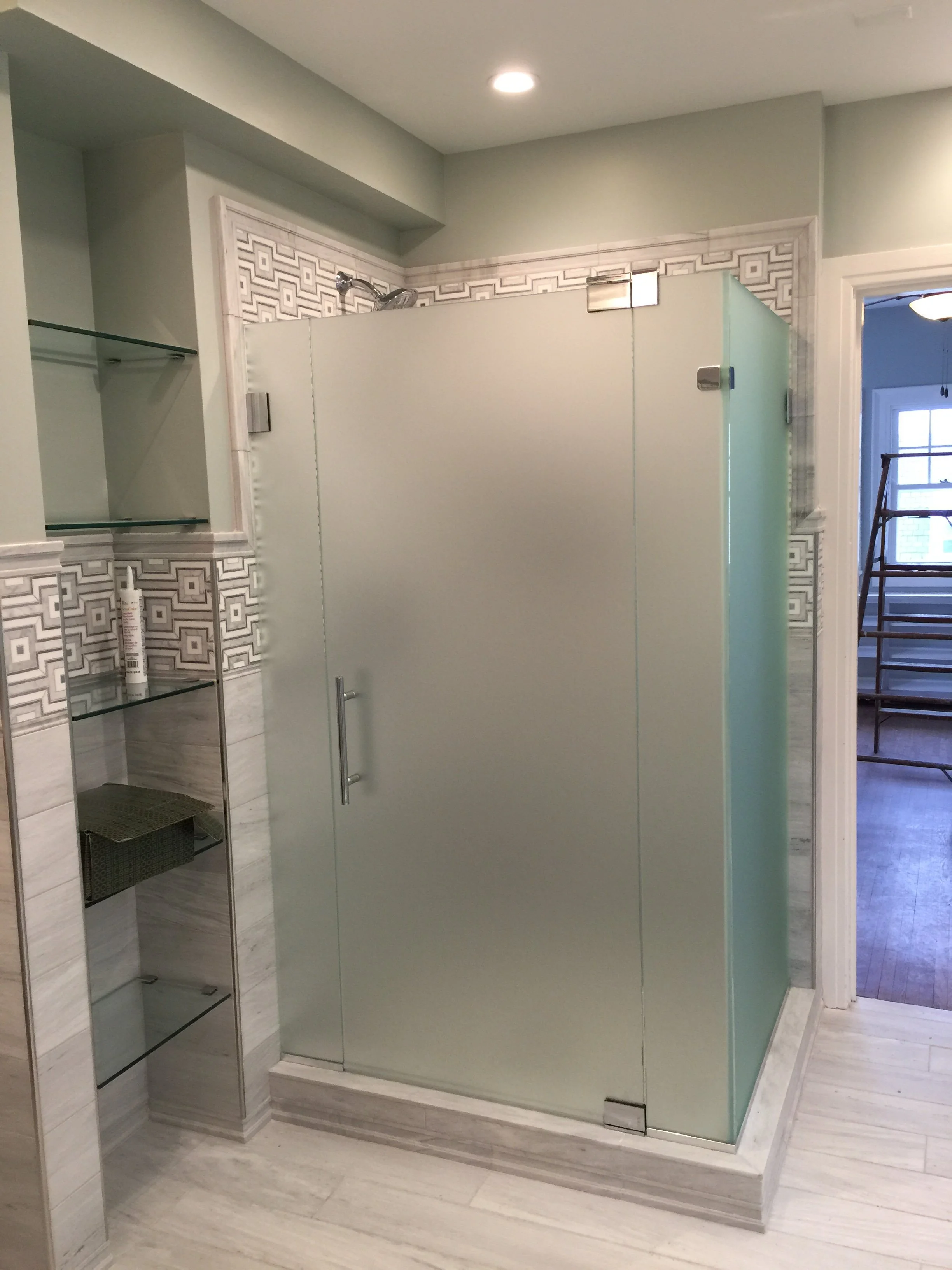 Finished glass shower enclosure and built-in shelving at the Marshall University President's House.