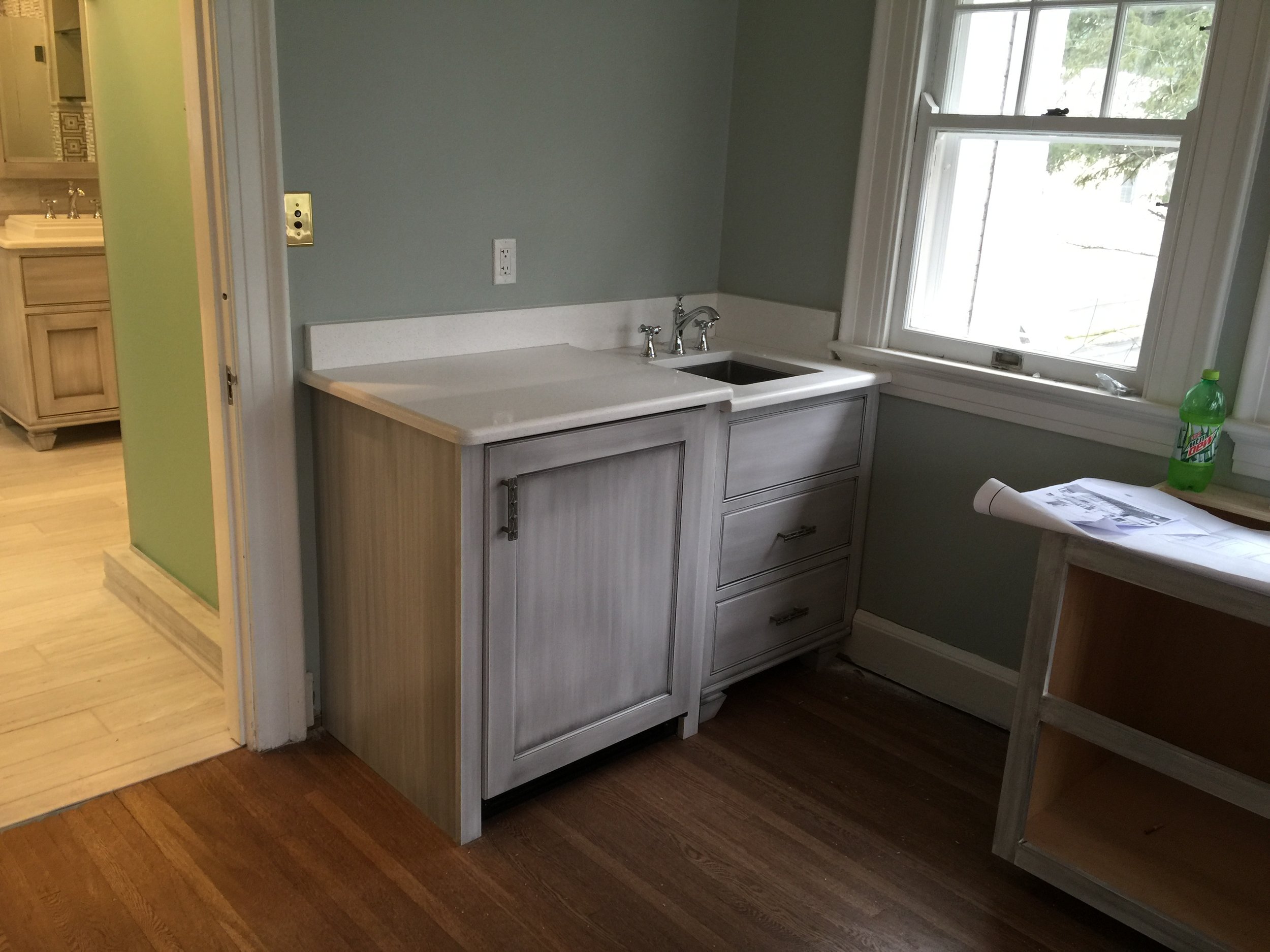 Renovated utility area with sink and cabinetry at the Marshall University President's House.