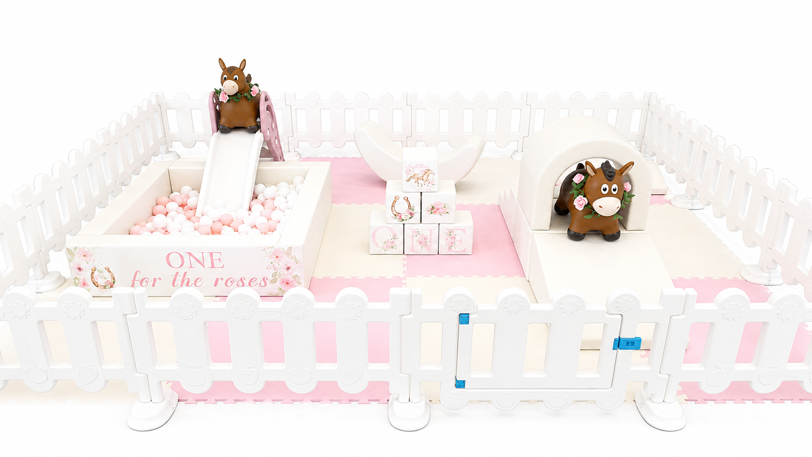 A pink and white children's play area with a small slide, ball pit, and decorative blocks spelling 'CUTE' with a unicorn illustration, surrounded by a white fence.