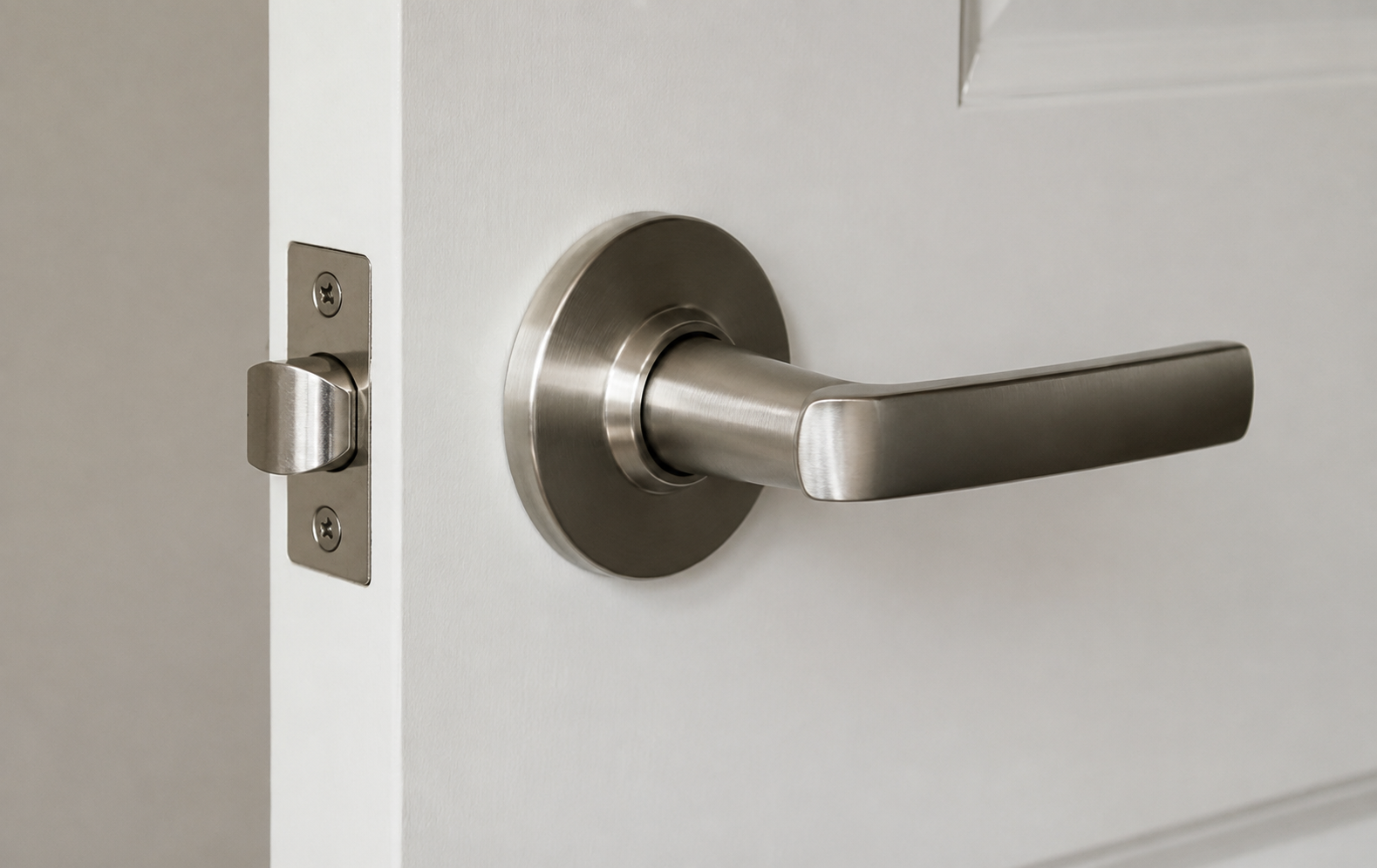 Close-up of a door handle and lock on a white door, with a modern stainless steel design.