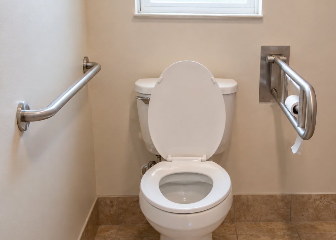 Toilet with grab bars on either side in a bathroom with a small window