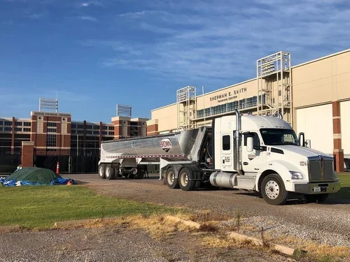 White semi-truck hauling a cement tanker trailer parked outside the Severne H. Smith water treatment facility