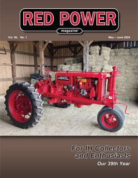 A red tractor inside a barn with wood walls and a concrete floor, featured on the cover of Red Power magazine for May-June 2024, celebrating its 39th year.