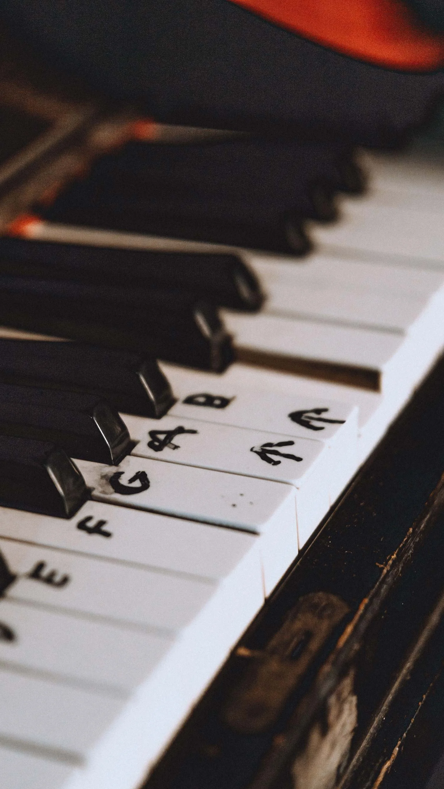 A close-up of piano keys with the notes labelled in marker.