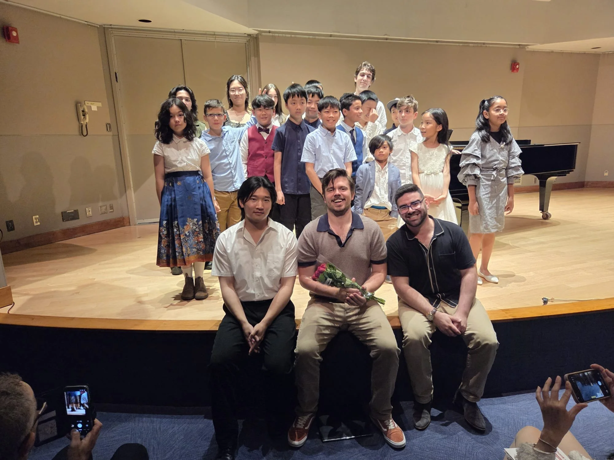 Elli Kozak music school students pose on stage in Ottawa after their piano recital with their teachers Eric Lee, Elli Kozak and Adam Sperry