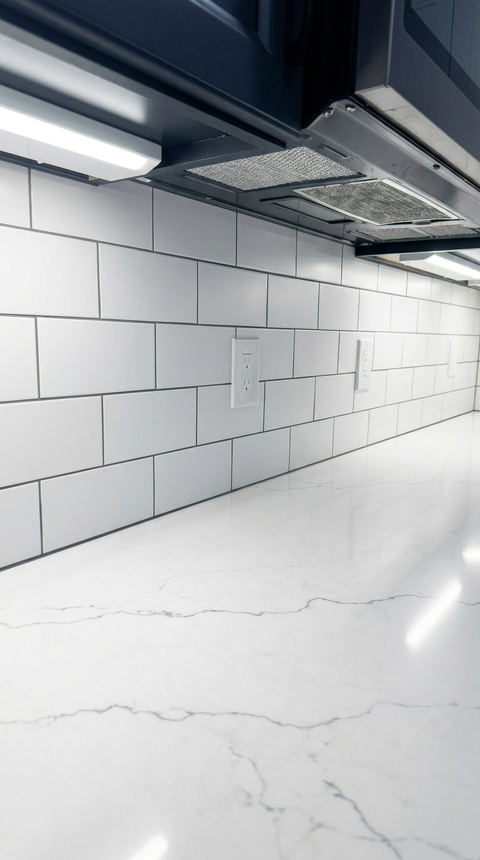 A kitchen backsplash with white subway tiles and a marble countertop.