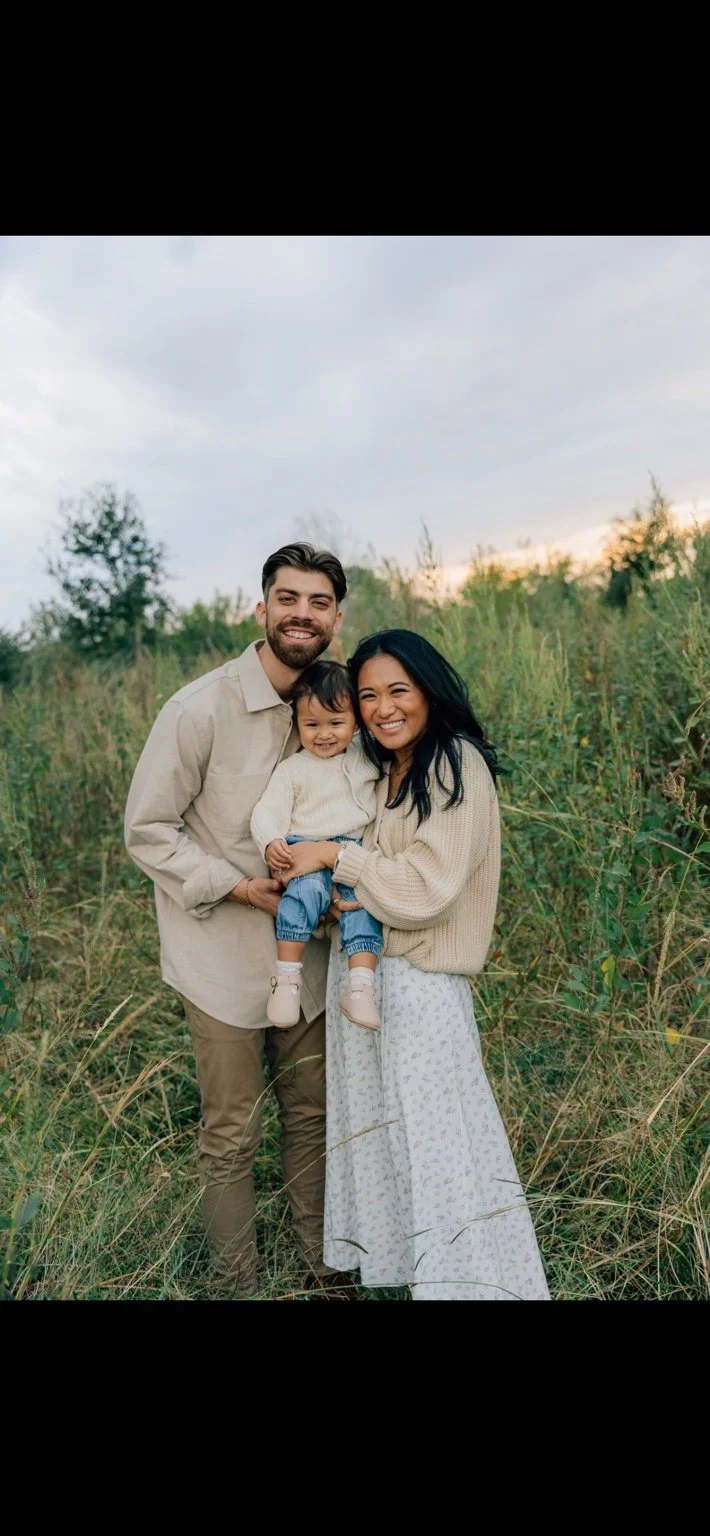 MomCha founders Dylan and Hannah with their daughter outdoors.