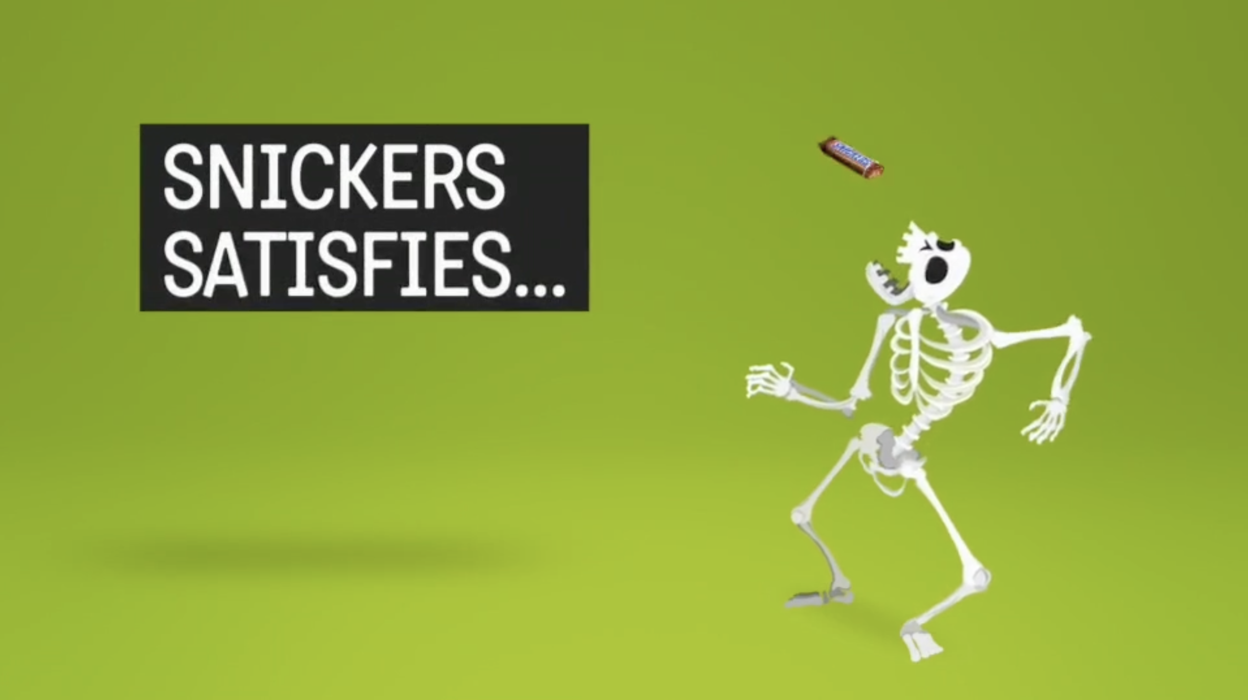 A skeleton running on a grassy field with a chocolate bar flying through the air. A black box with white text reads "Snickers satisfies...".