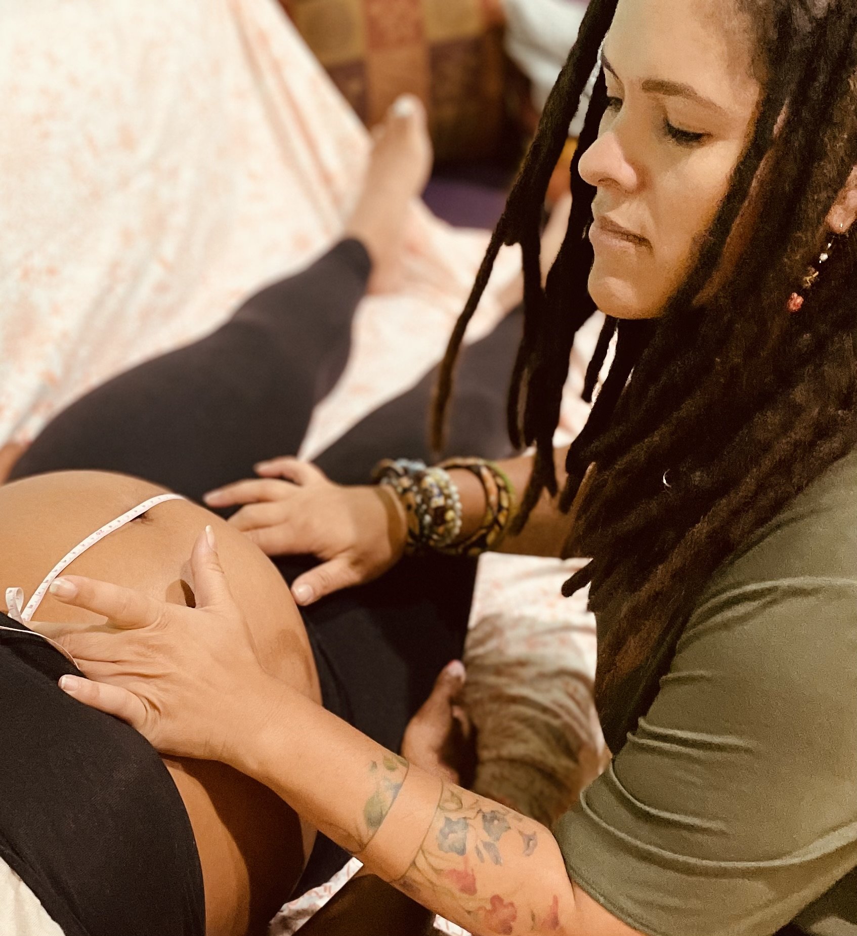 Jessica Epting measuring a pregnant client's fundal height during a home prenatal visit.