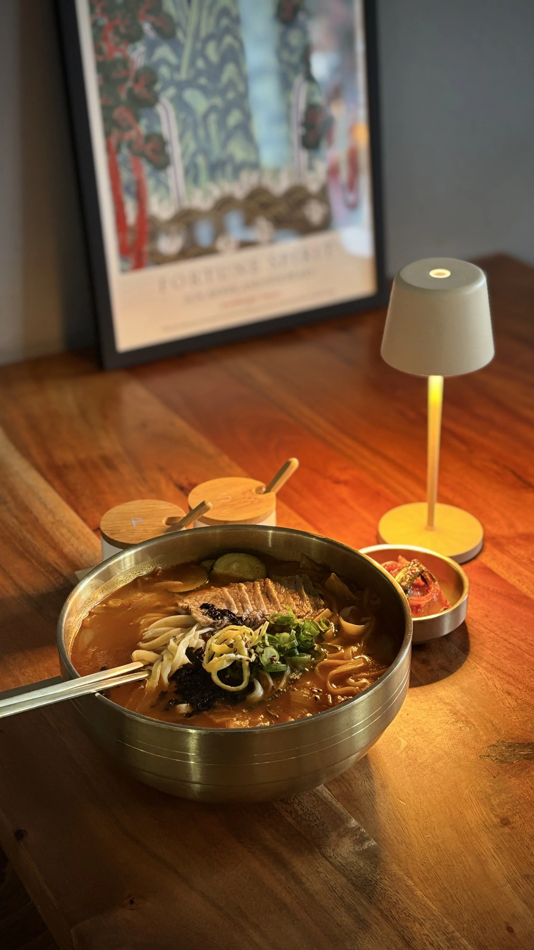 Kimchi kalguksu with braised beef and knife-cut noodles on a warmly lit table at Misty Pot Korean.