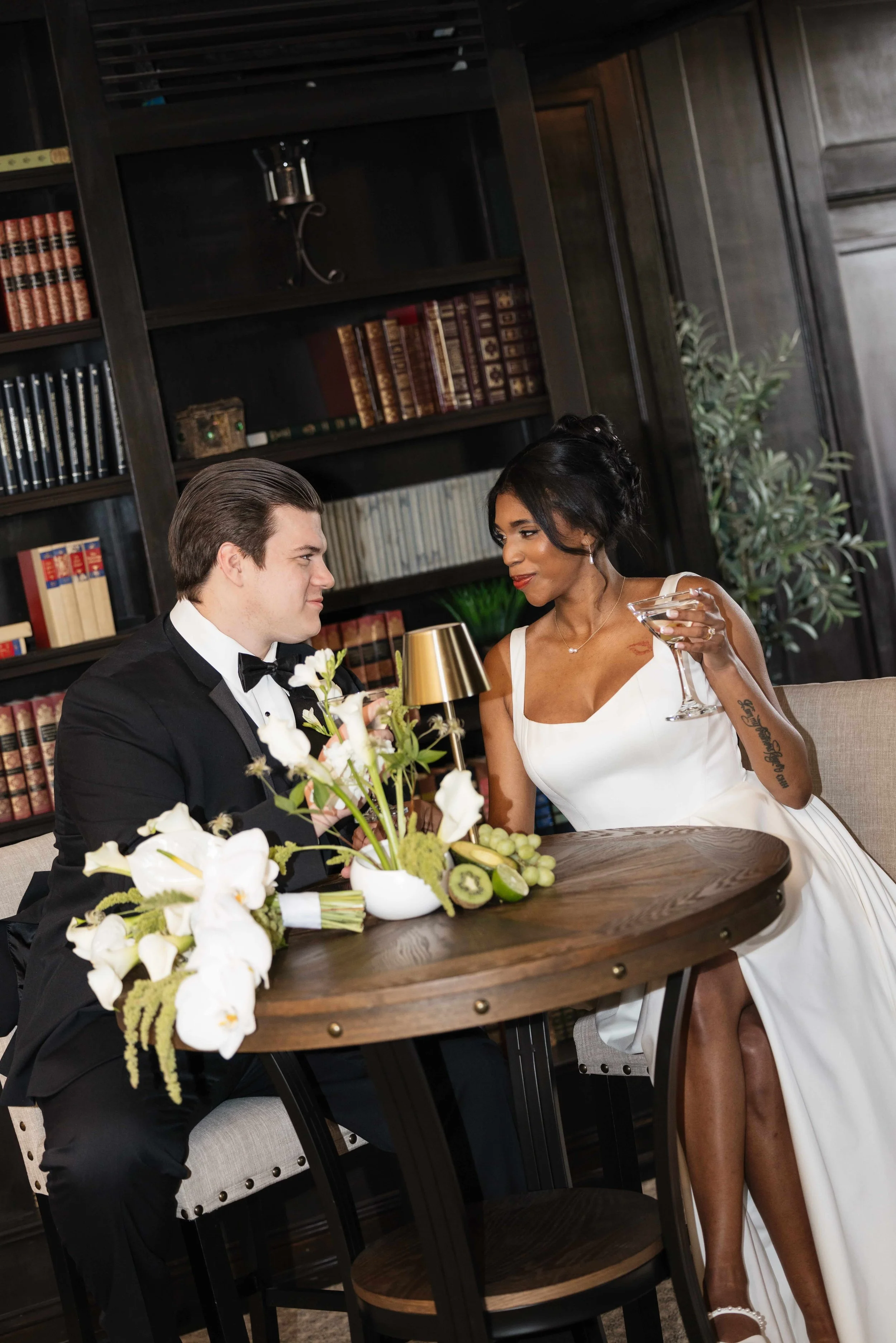 Multi-racial couple at their Seattle wedding reception, surrounded by green and white flowers