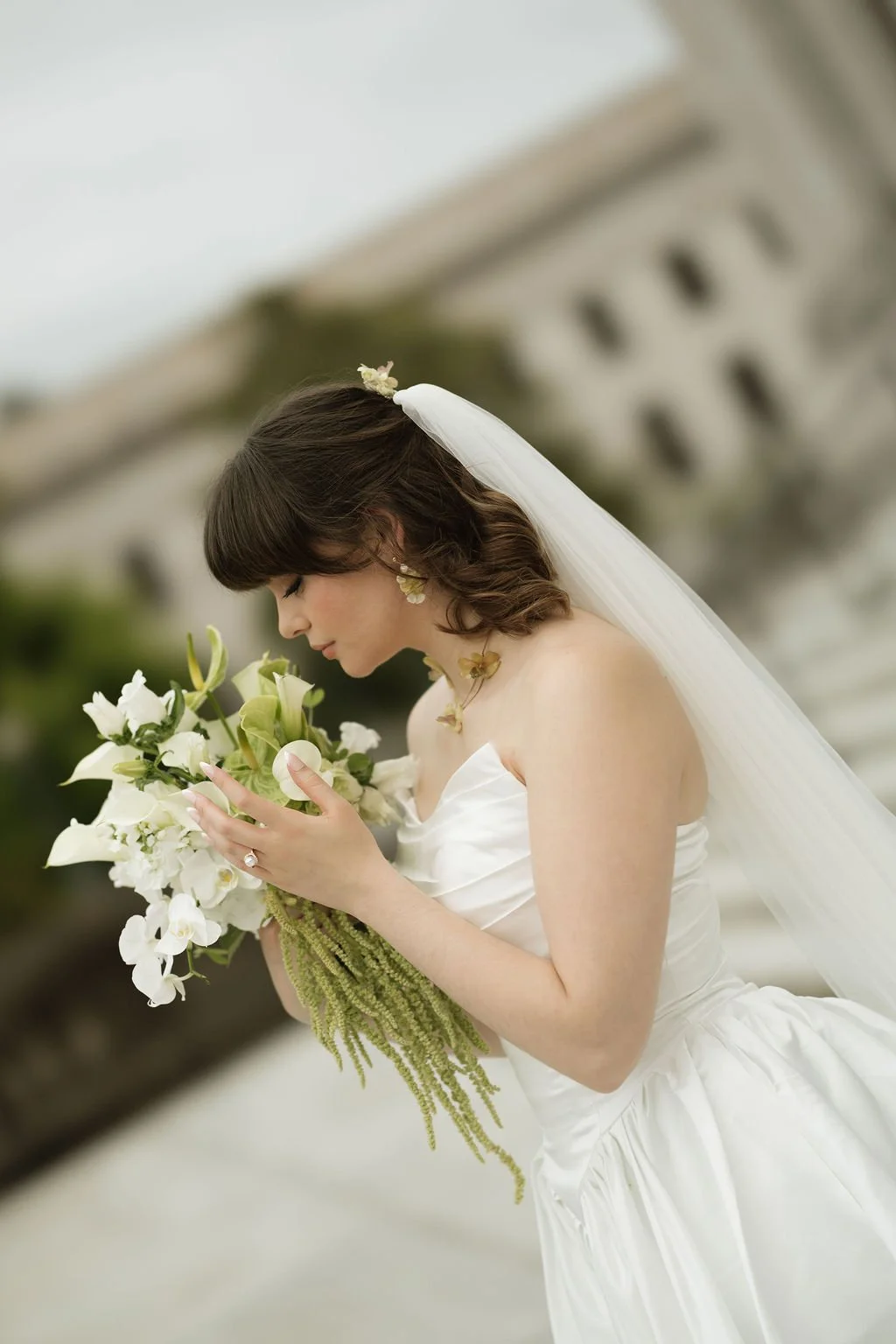 bride smelling Green and white cascading bouquet