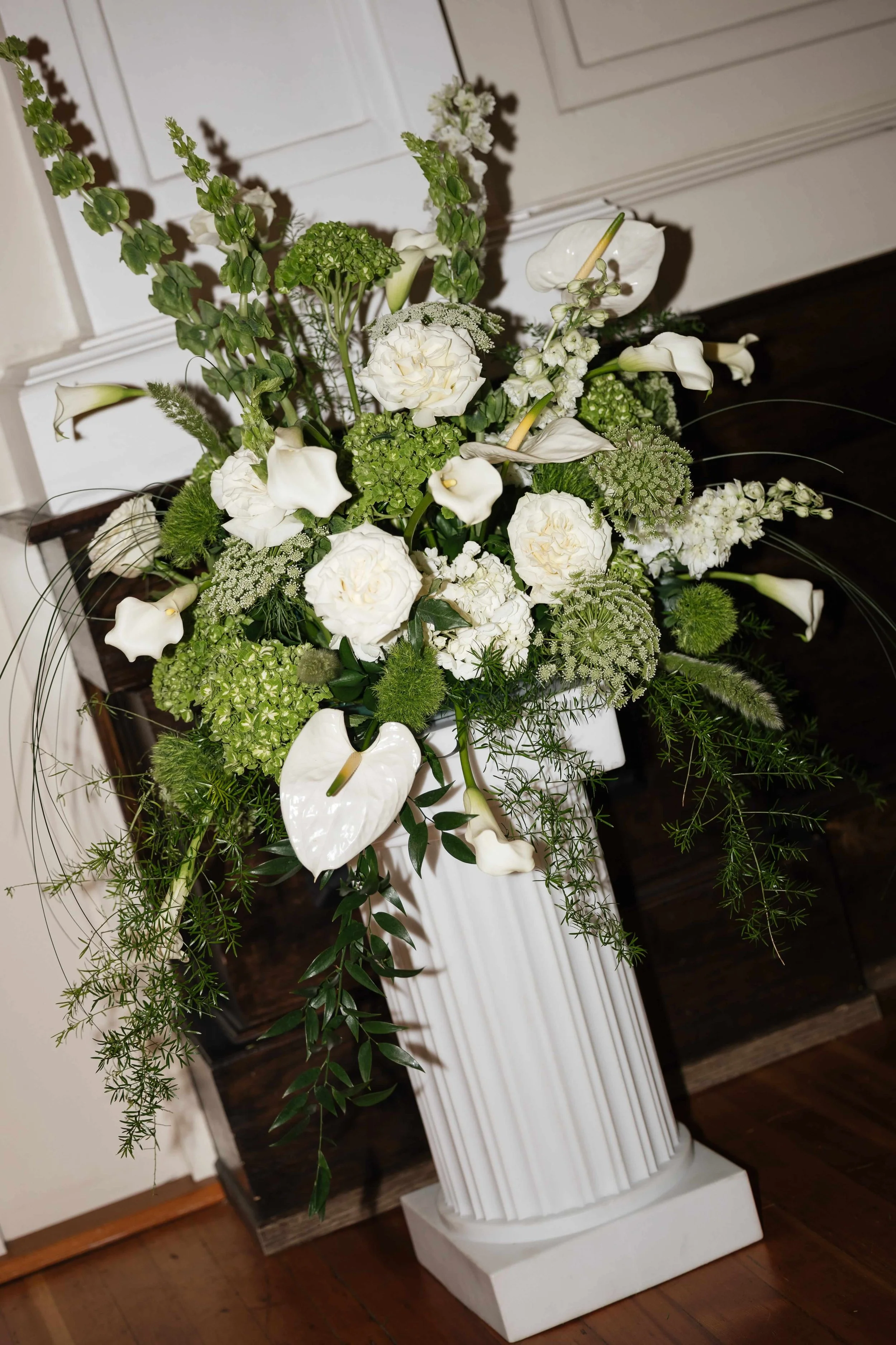 Green and white floral arrangement on a white column at a Tacoma Seattle Washington wedding by Love Letter Floral and Events