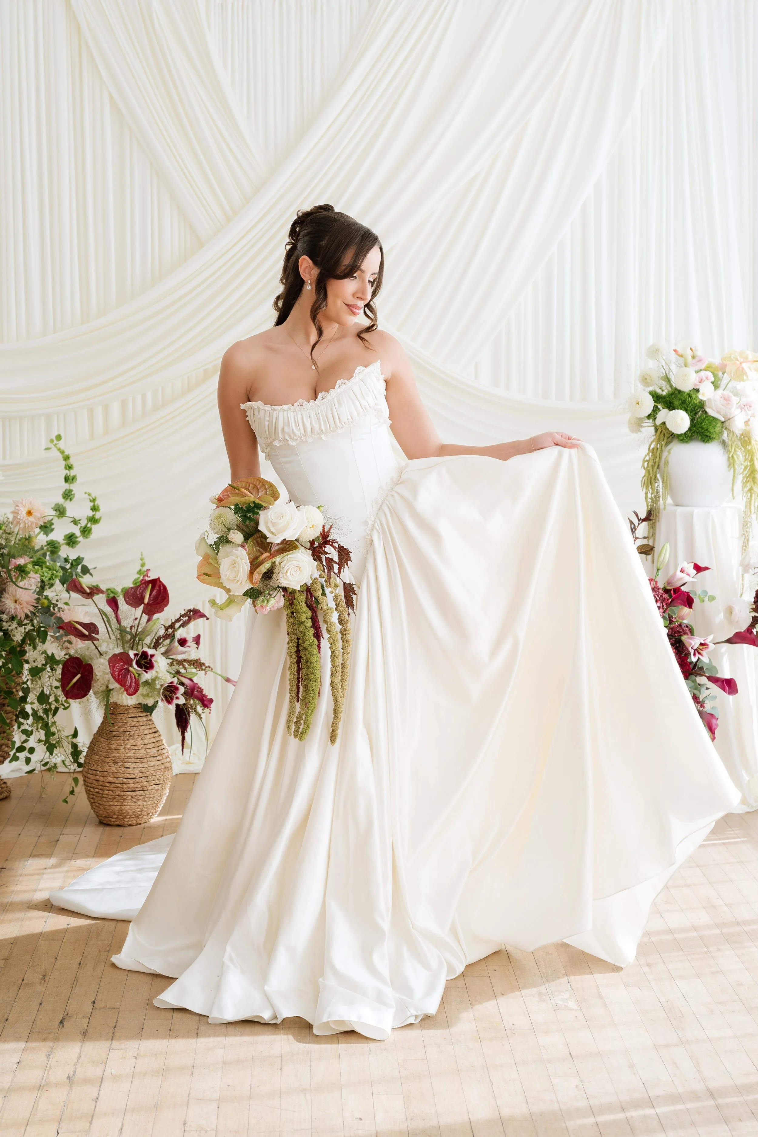 bride holding gorgeous modern bridal bouquet with blush iridescent anthurium, garden roses, calla lilies, and green hanging amaranthus by Love Letter Florals in Seattle and Tacoma