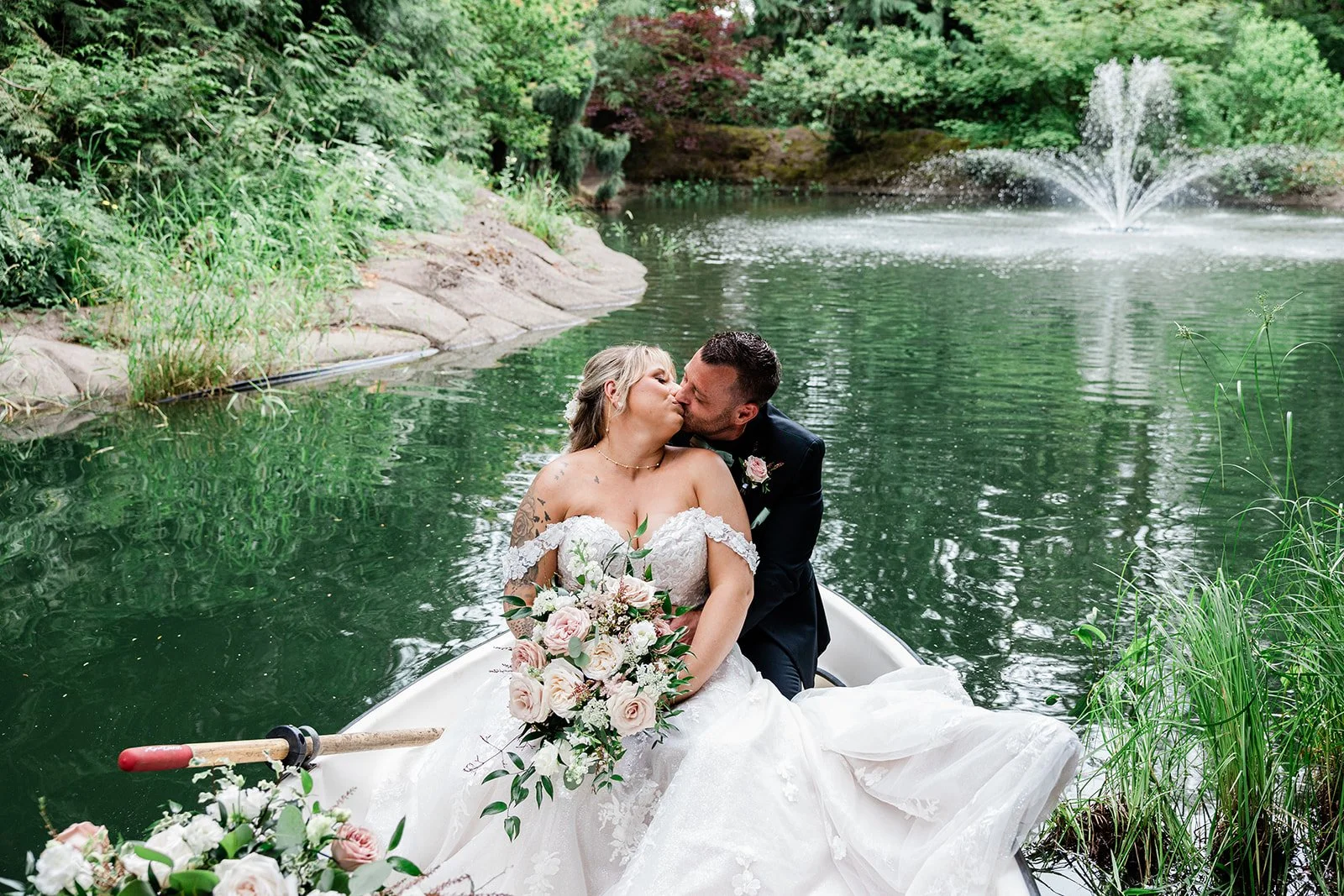 bride and groom in boat holding Cascading blush and white bridal bouquet by Love Letter Floral and Event
