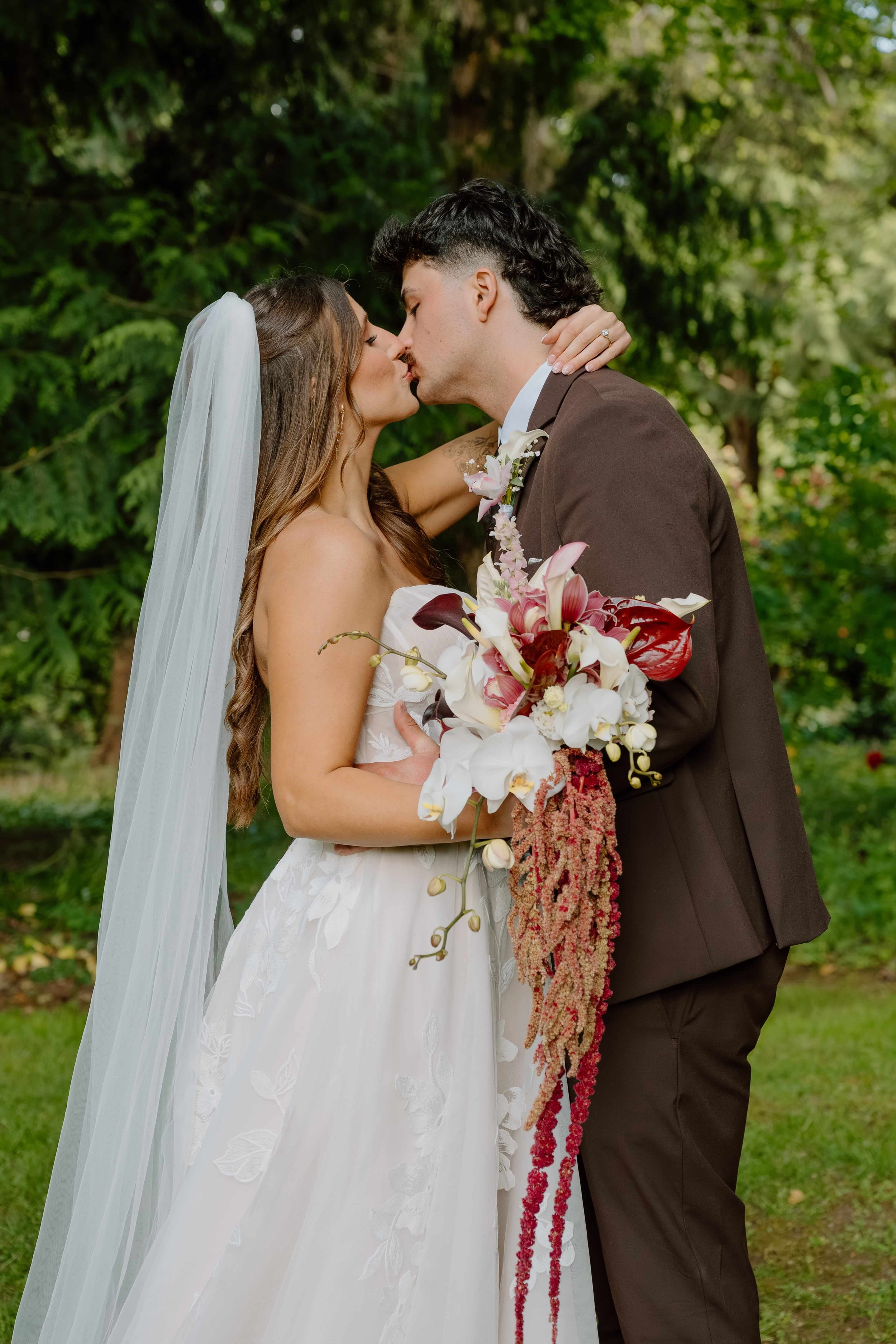 Bride and Groom at a Pacific Northwest wedding carrying lovely white and antique red cascading bouquets by Love Letter Floral and events 