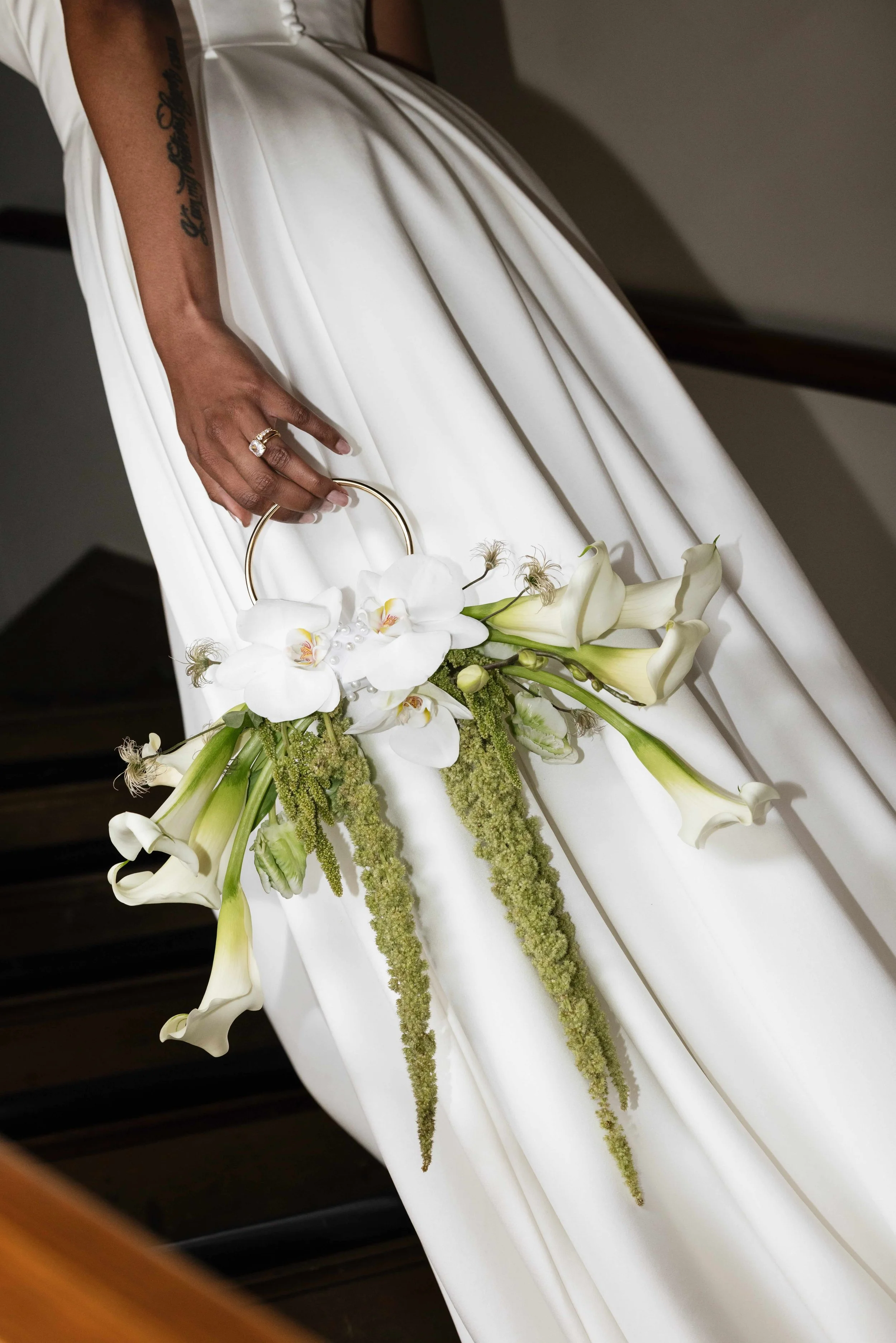 green and white ring floral purse by Love Letter Floral and Events being carried by a Seattle bride