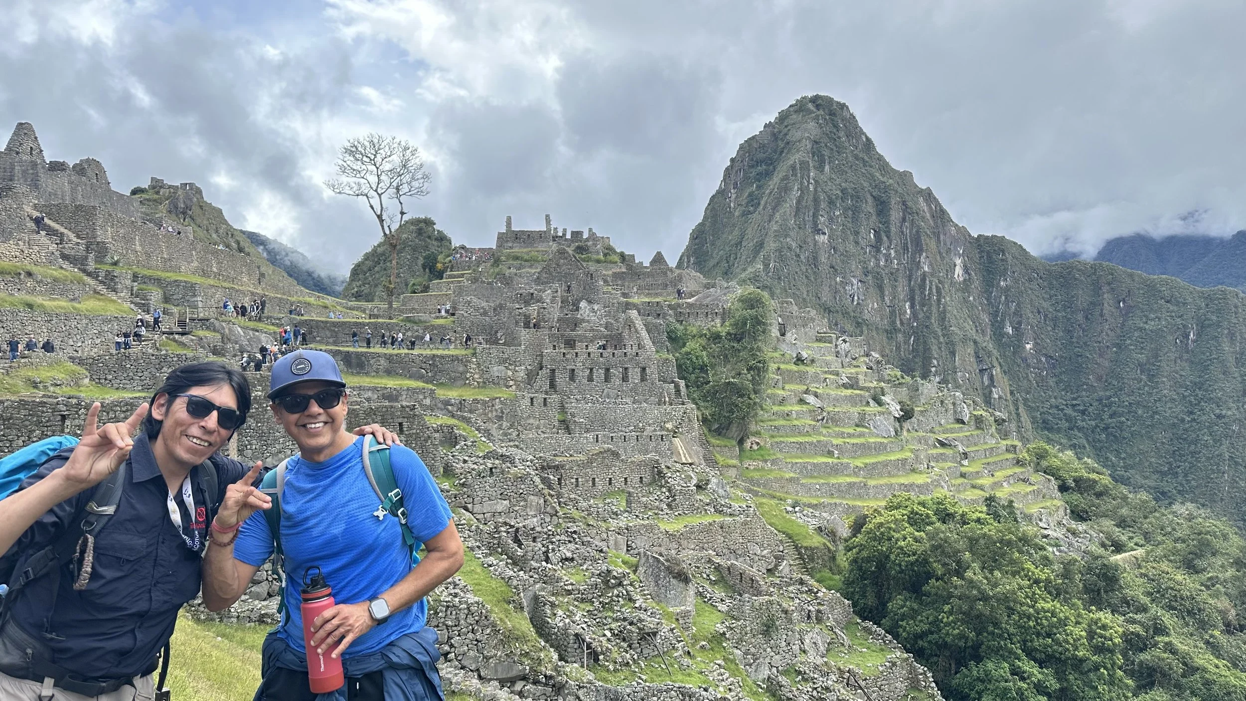 Hiker and guide posing together at Machu Picchu after the Inca Trail trek