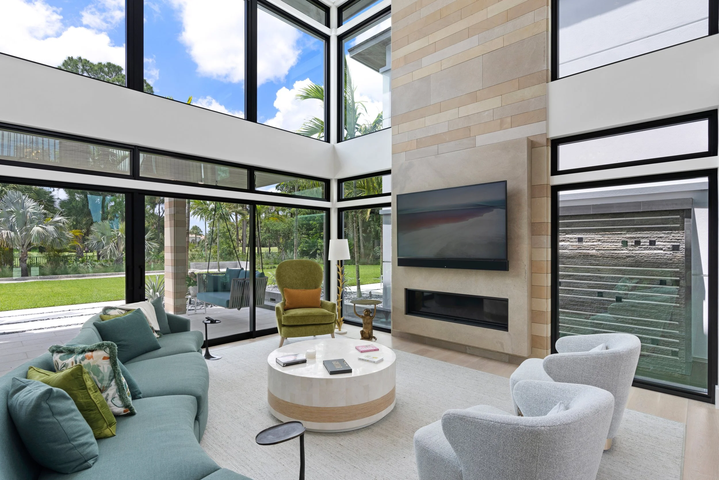 Open living and dining space with in-ceiling audio and a television above the fireplace