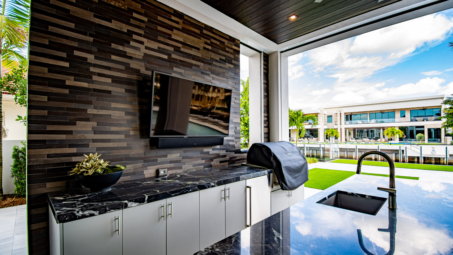 Summer kitchen with an outdoor-rated display facing the water, built for sun and salt