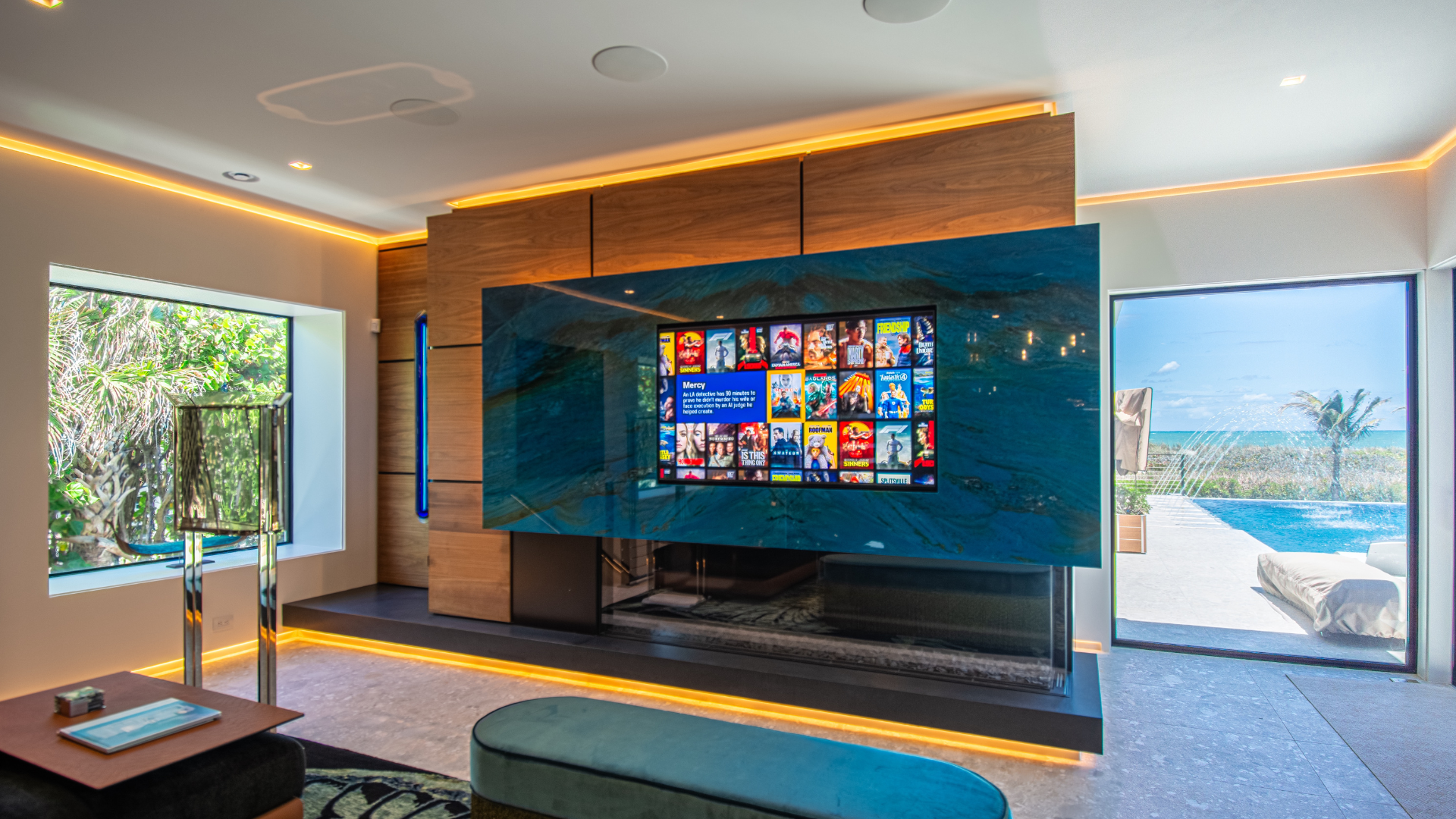 Media room with recessed display, stone feature wall, and in ceiling speakers